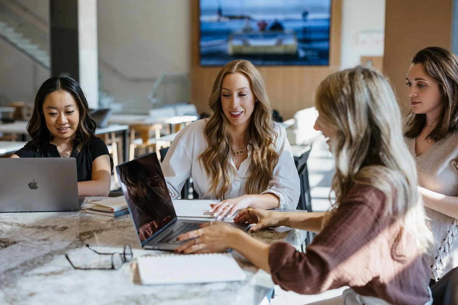 Creme Brands team meeting around a laptop