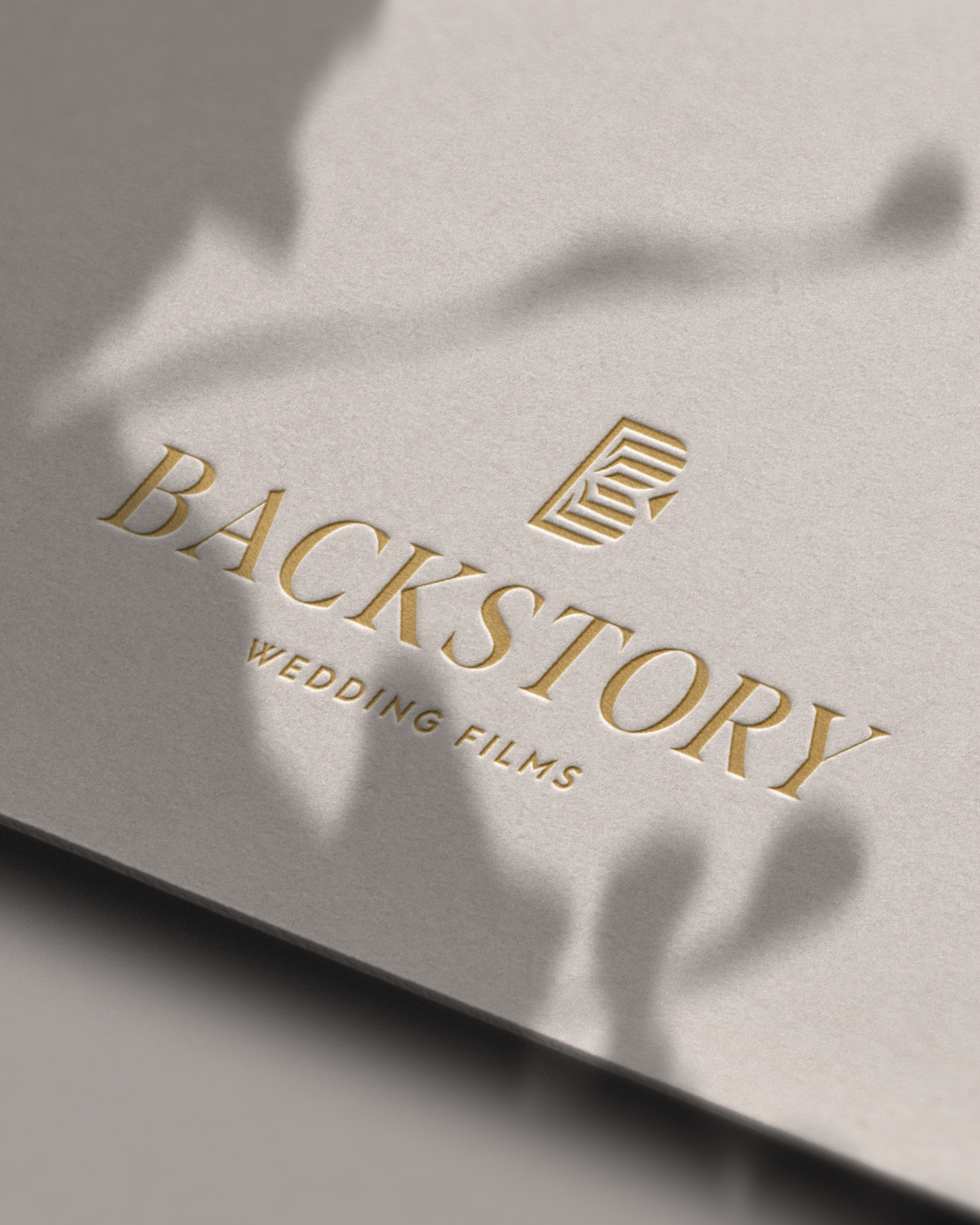 Backstory Wedding Films logo embossed in gold on cream cardstock