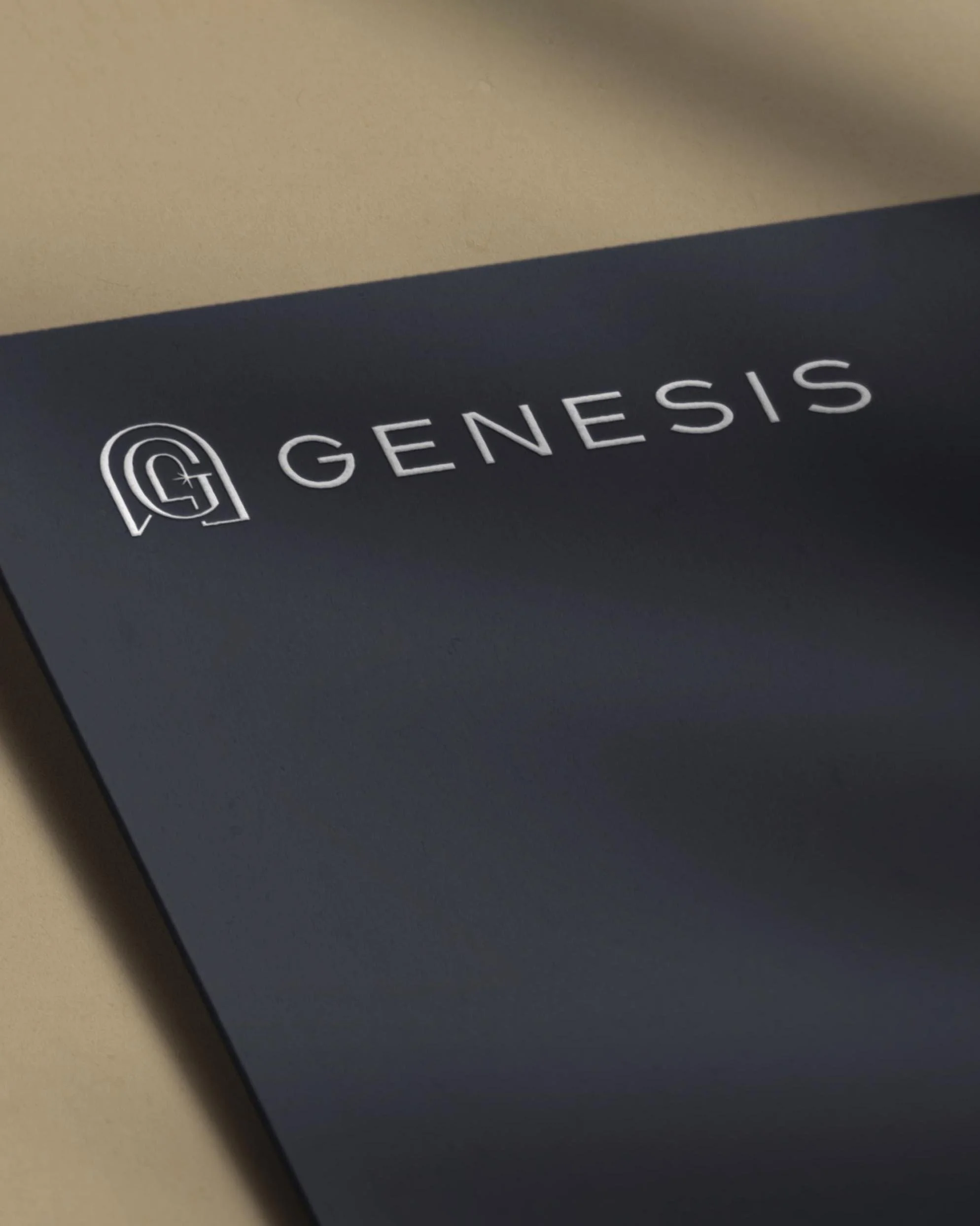 Genesis logo embossed on navy cardstock