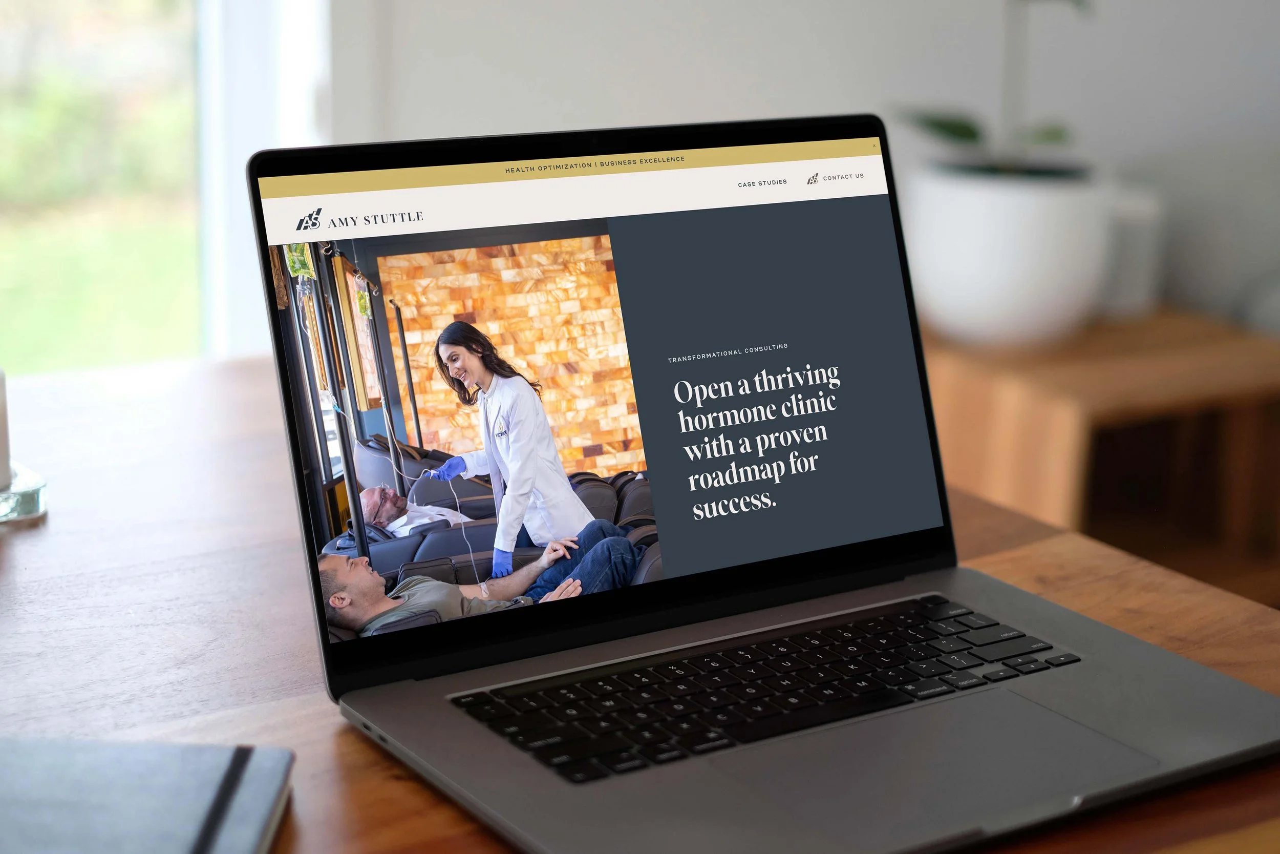 laptop displaying the hero section of Amy Stuttle Consulting homepage with strong website copy: "Open a thriving hormone clinic with a proven roadmap for success."