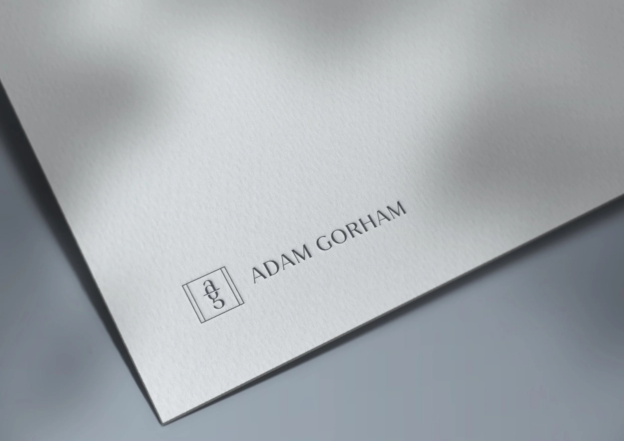 Adam Gorham logo embossed on white cardstock