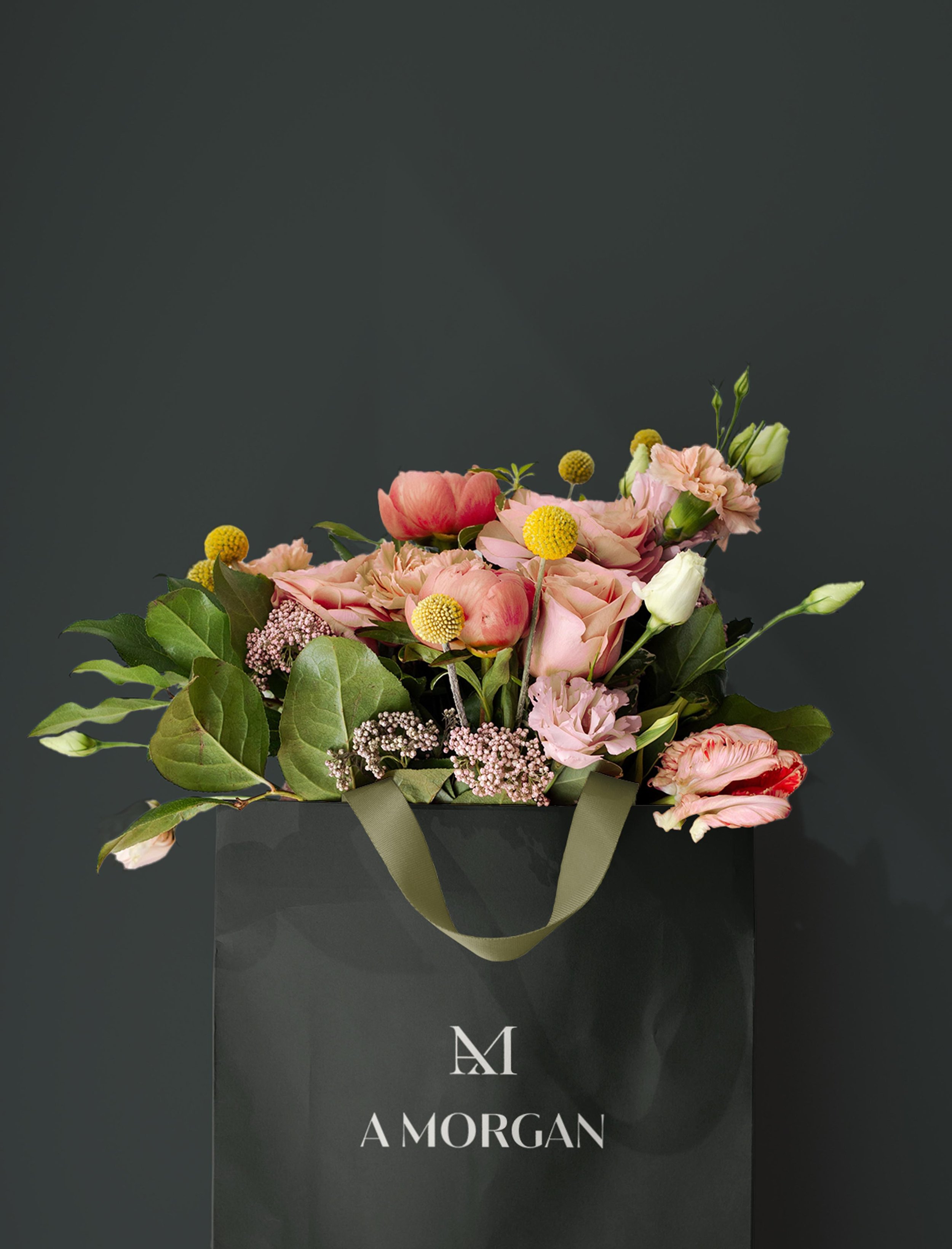 gift bag printed with the A Morgan Floral logo, overflowing with flowers against a charcoal background