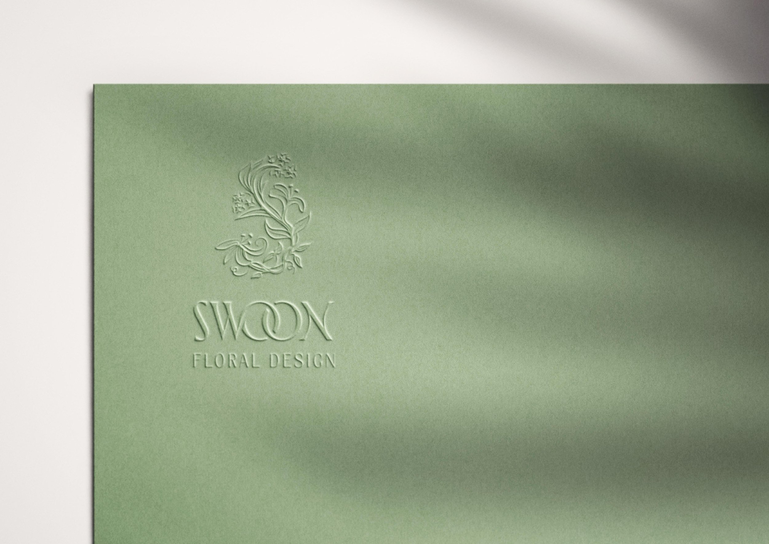 green cardstock embossed with the Swoon Floral Design logo