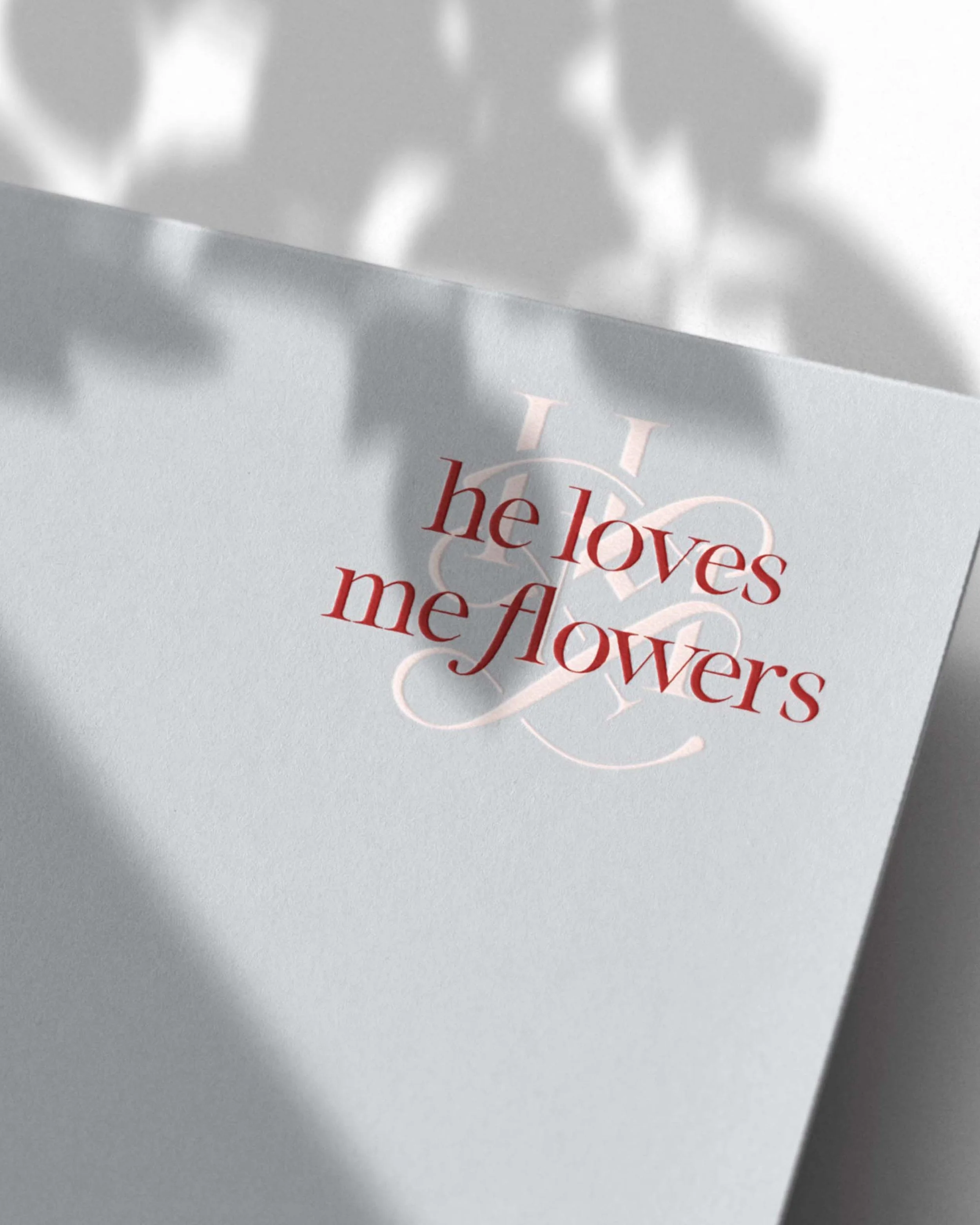 light blue cardstock embossed with the He Loves Me Flowers logo