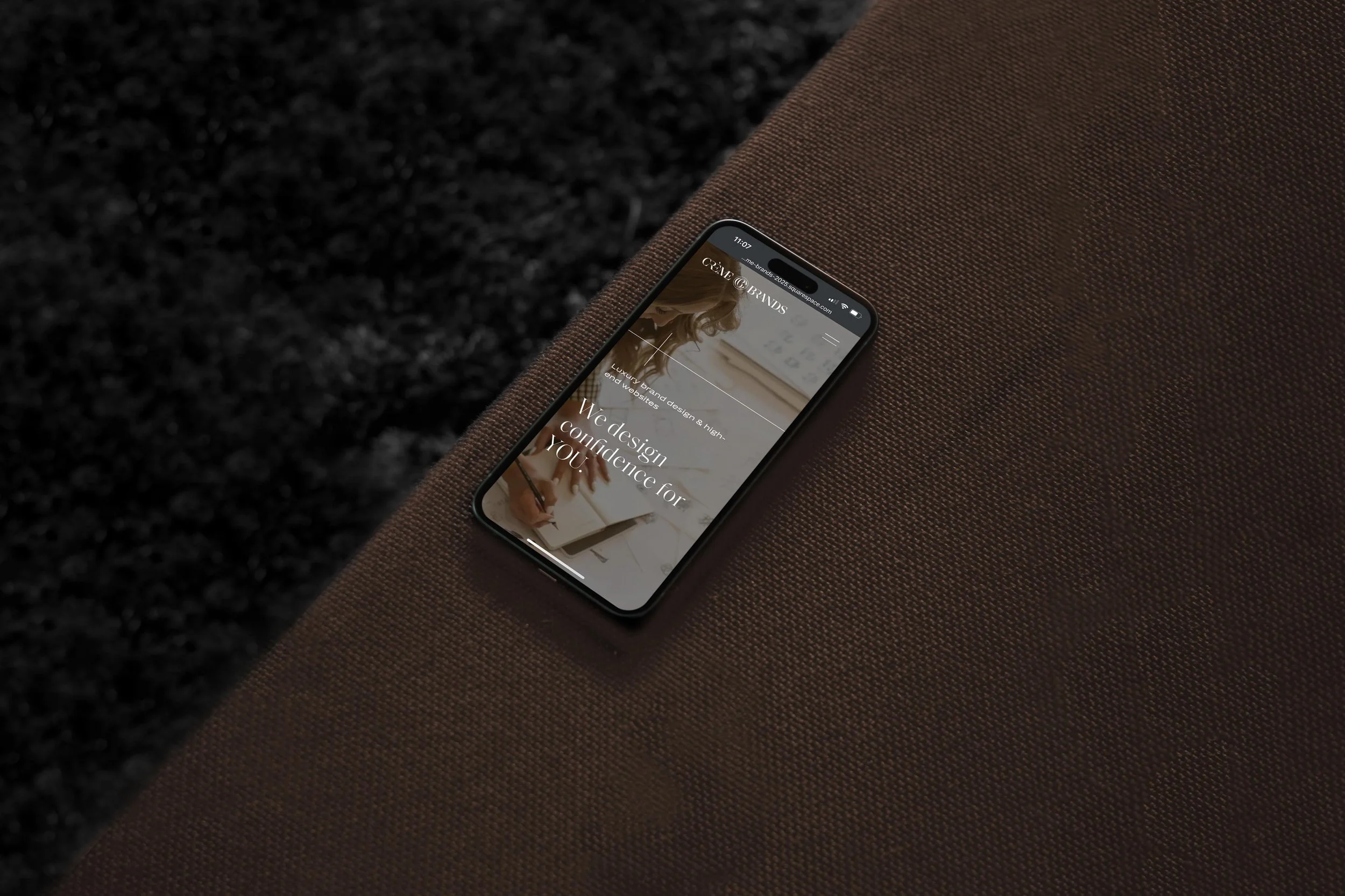 iPhone showing Creme Brands website with headline, "We design confidence for you"