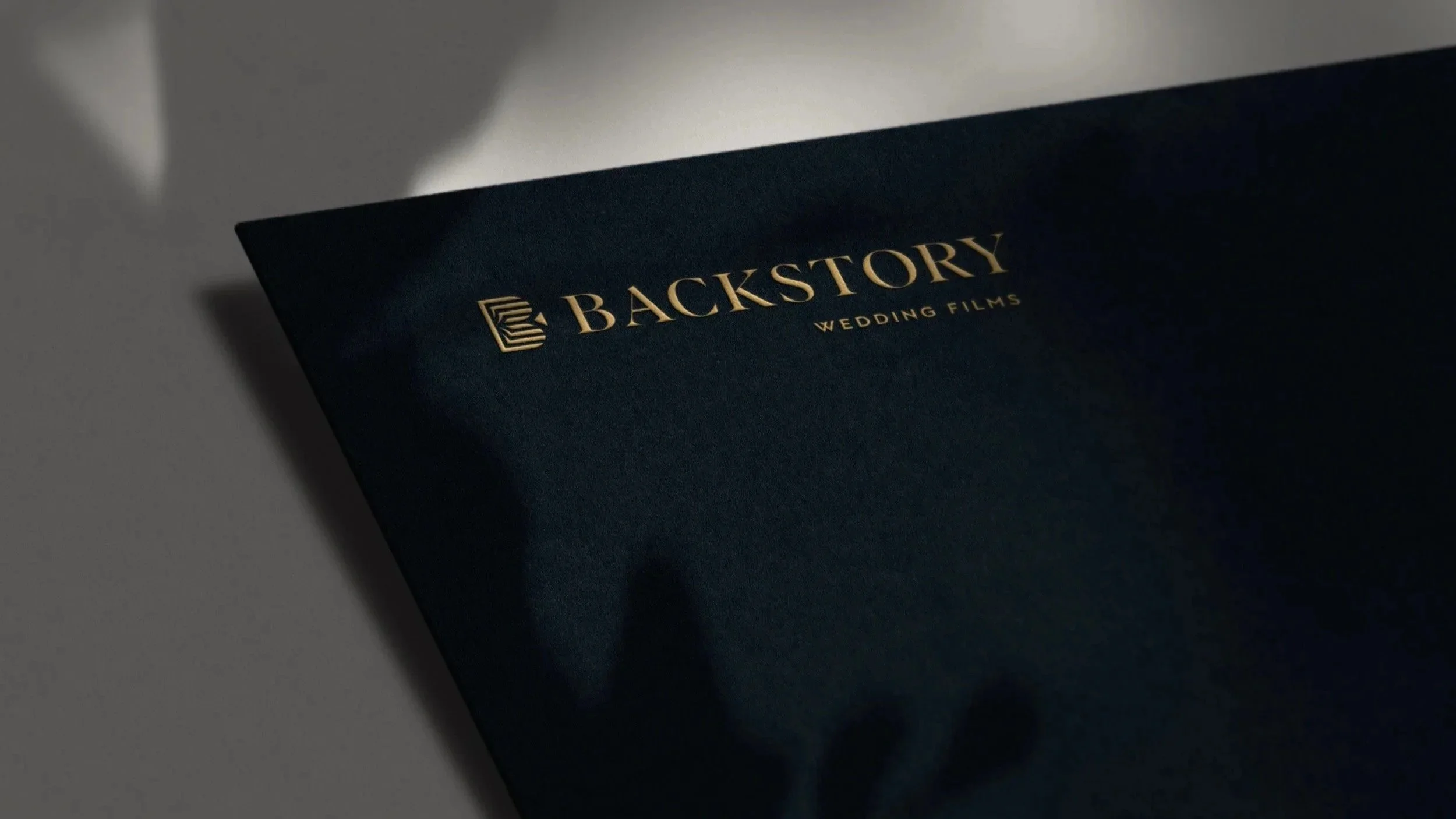 Backstory Wedding Films logo gold foil printed on black cardstock