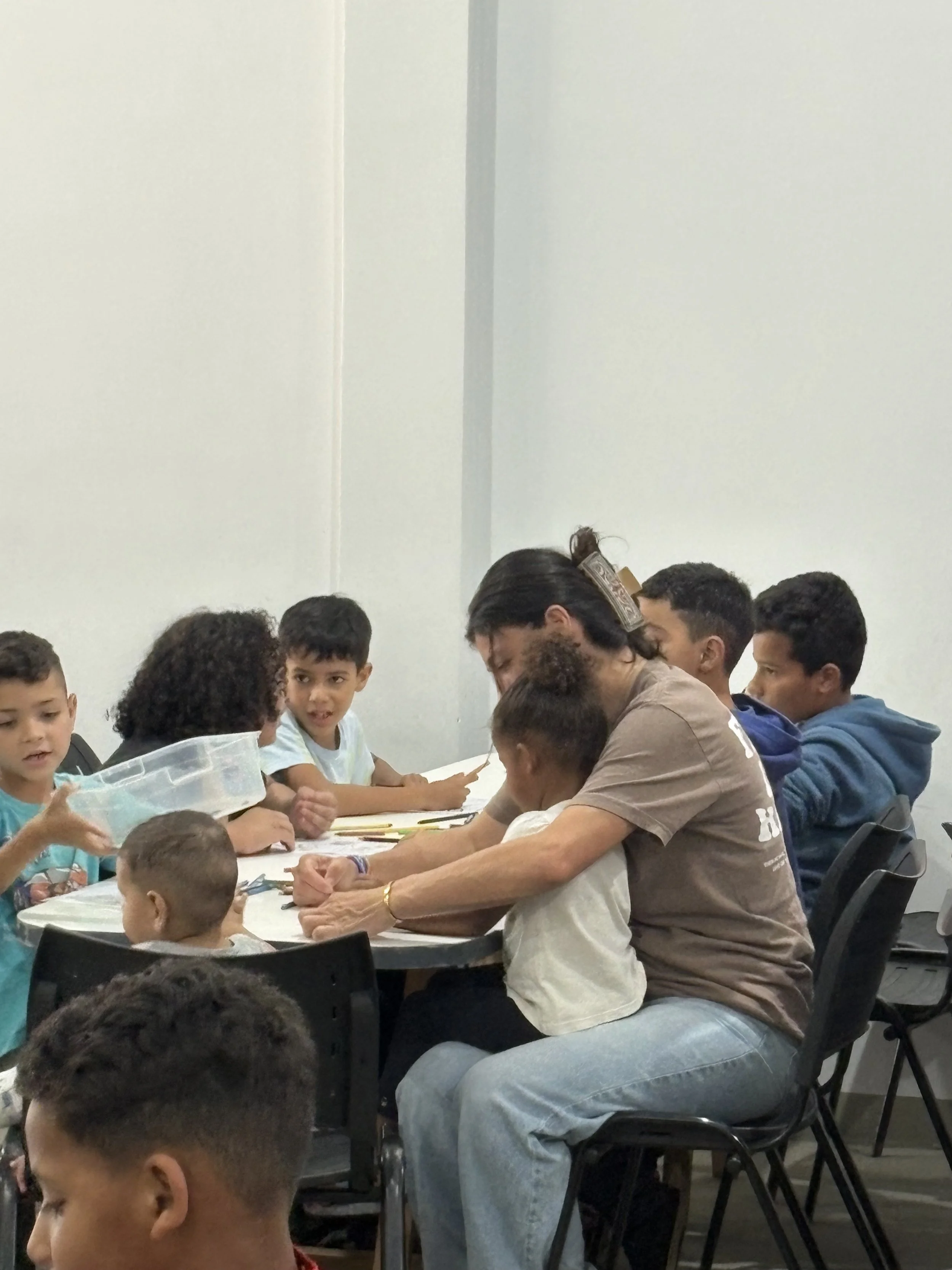 A group of children and an adult man in Brazil, listening to a lesson on Jesus' love for them.