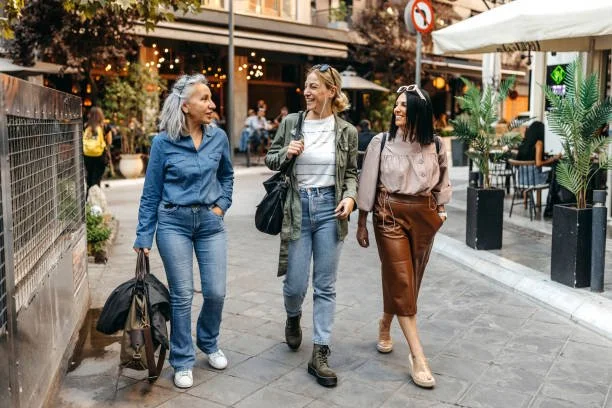 A group of women smiling and talking as they walk down the street
