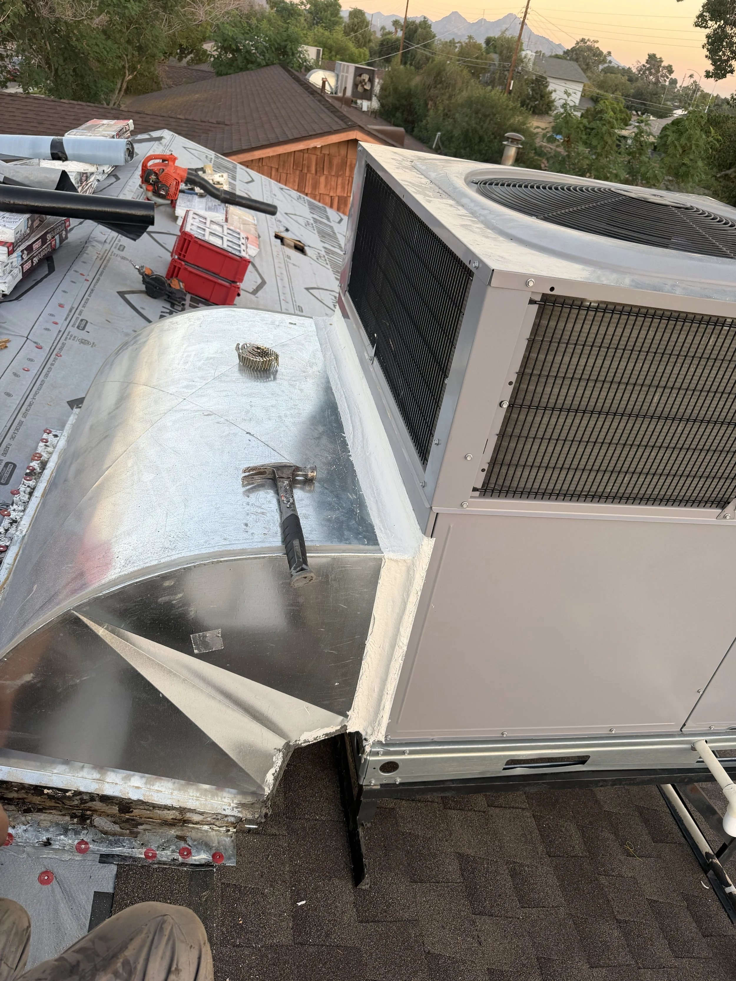 Roof with HVAC system and tools, including a hammer, toolbox, and duct tape, during installation or maintenance.