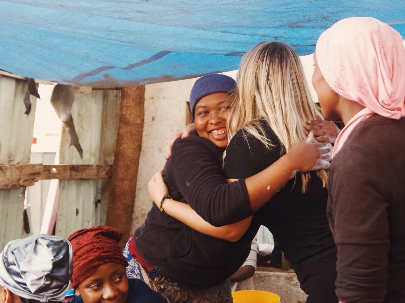 En grupp kvinnor som kramas och leker tillsammans utomhus.