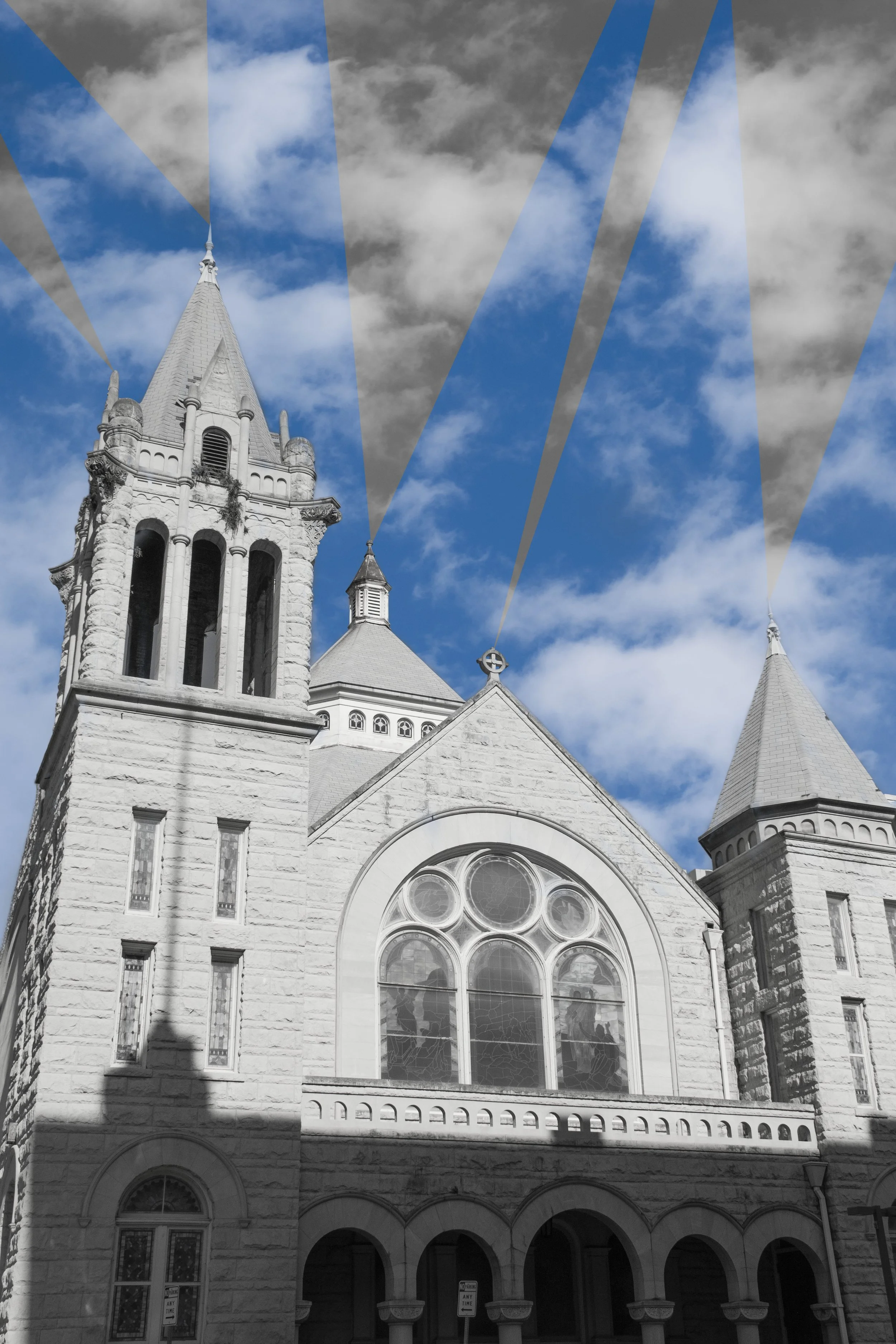 A church with gothic architecture, twin spires, large stained glass windows, and stone walls, under a partly cloudy sky.