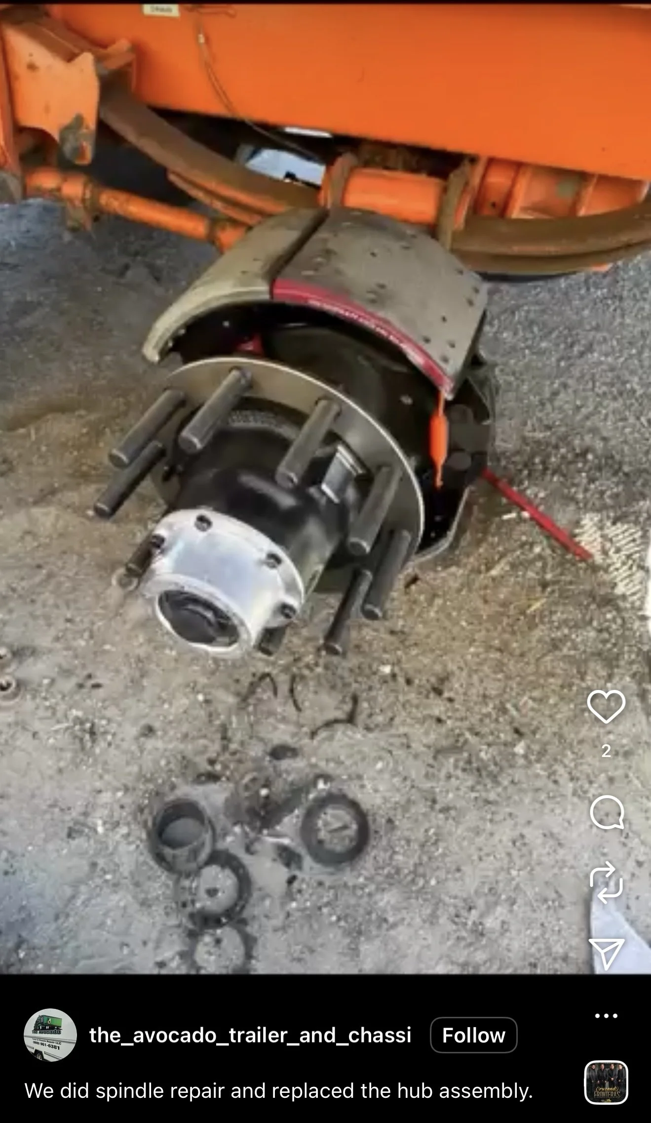 A collapsed tractor hub assembly with replacement parts on the ground, indicating recent spindle repair and hub replacement.