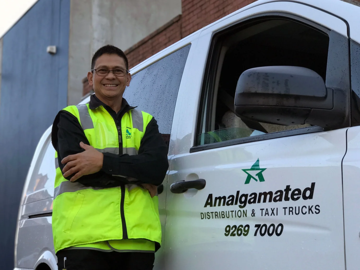 Amalgamated driver beside a branded delivery vehicle in Melbourne