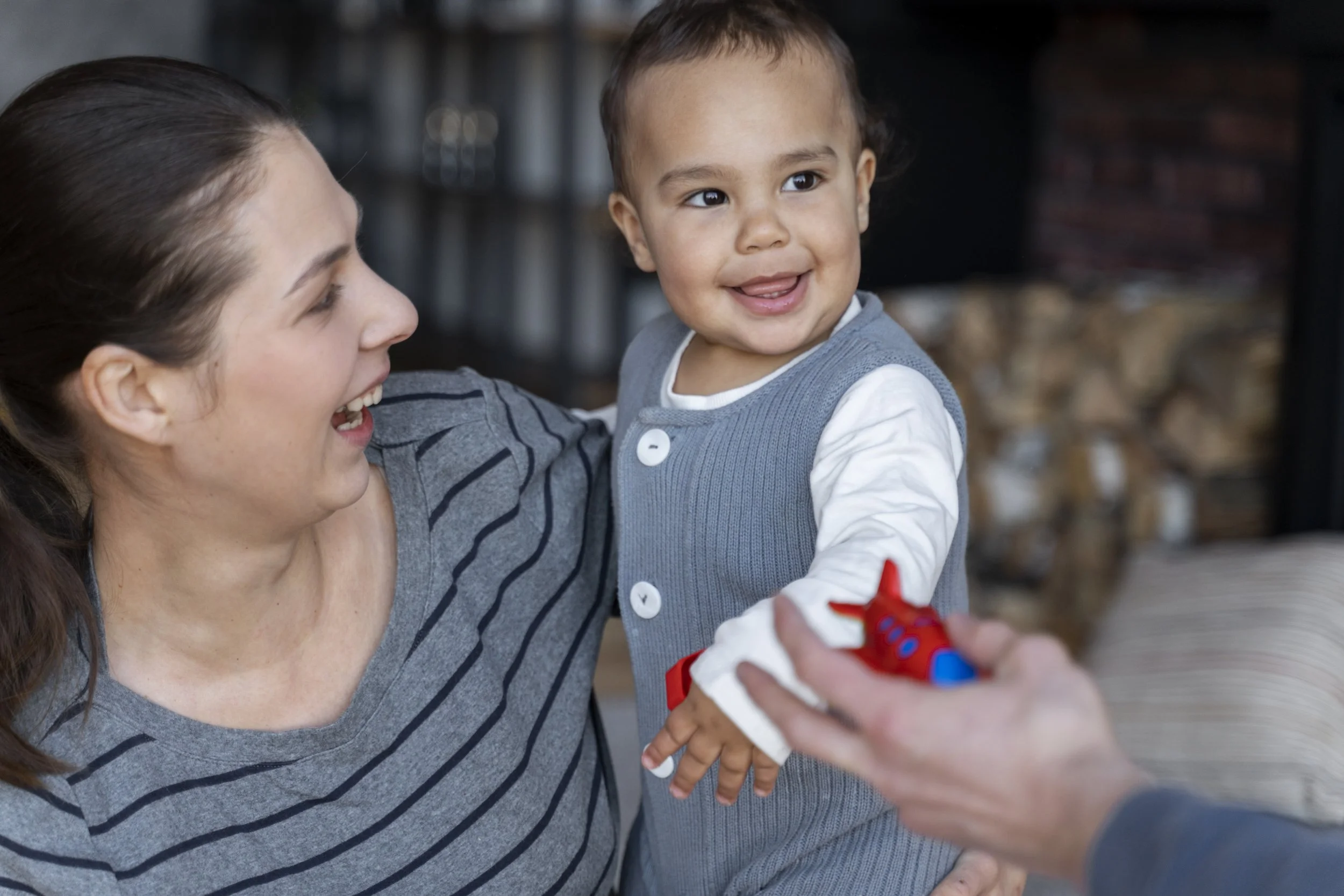 adorable-smiley-held-by-his-mother-offered-toy.jpg