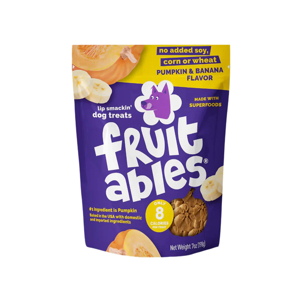 Purple bag of Fruit Ables dog treats with banana and pumpkin flavor, featuring a purple dog cartoon logo, and text indicating no added soy, corn, or wheat, and highlighting pumpkin as the main ingredient.