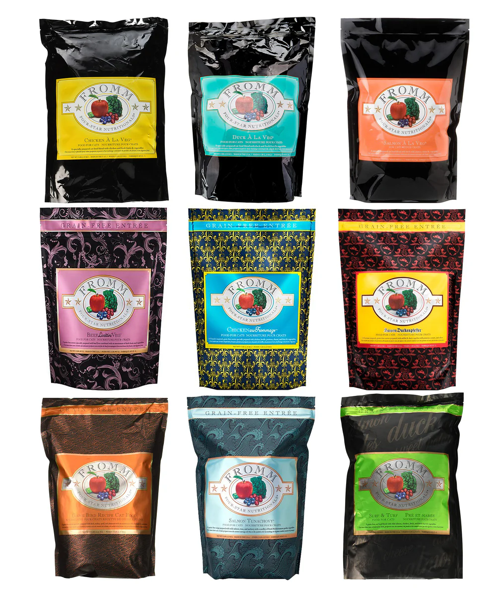 Nine black packages of cat food with colorful and patterned labels, featuring images of apples, grapes, and berries.