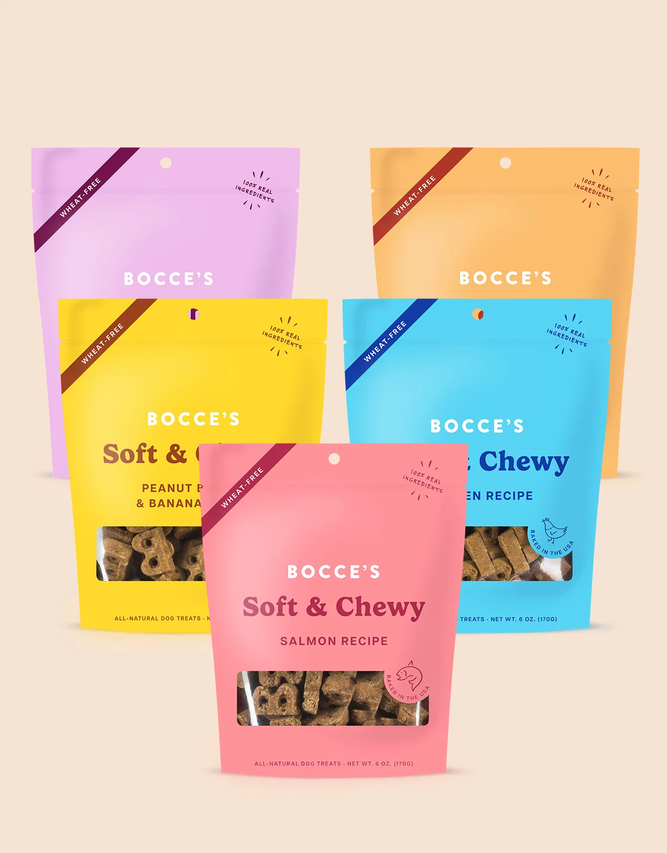 Collection of five colorful bocce's dog treat packages, each labeled with a different flavor including salmon, peanut butter, banana, apple, and an unlabeled flavor, featuring clear windows showing the treats inside and labels indicating they are wheat-free and made with real ingredients.