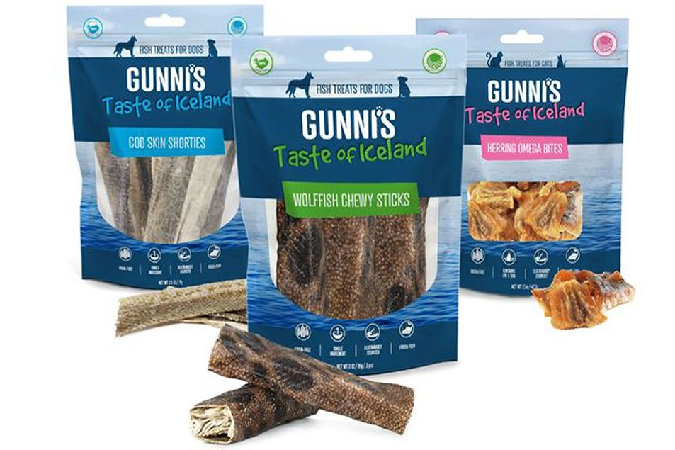 Three packages of Gunni's Taste of Iceland dog treats with fish-themed labels, including cod skin shorties, wolffish chewy sticks, and herring omega bites, displayed with some treats in front.