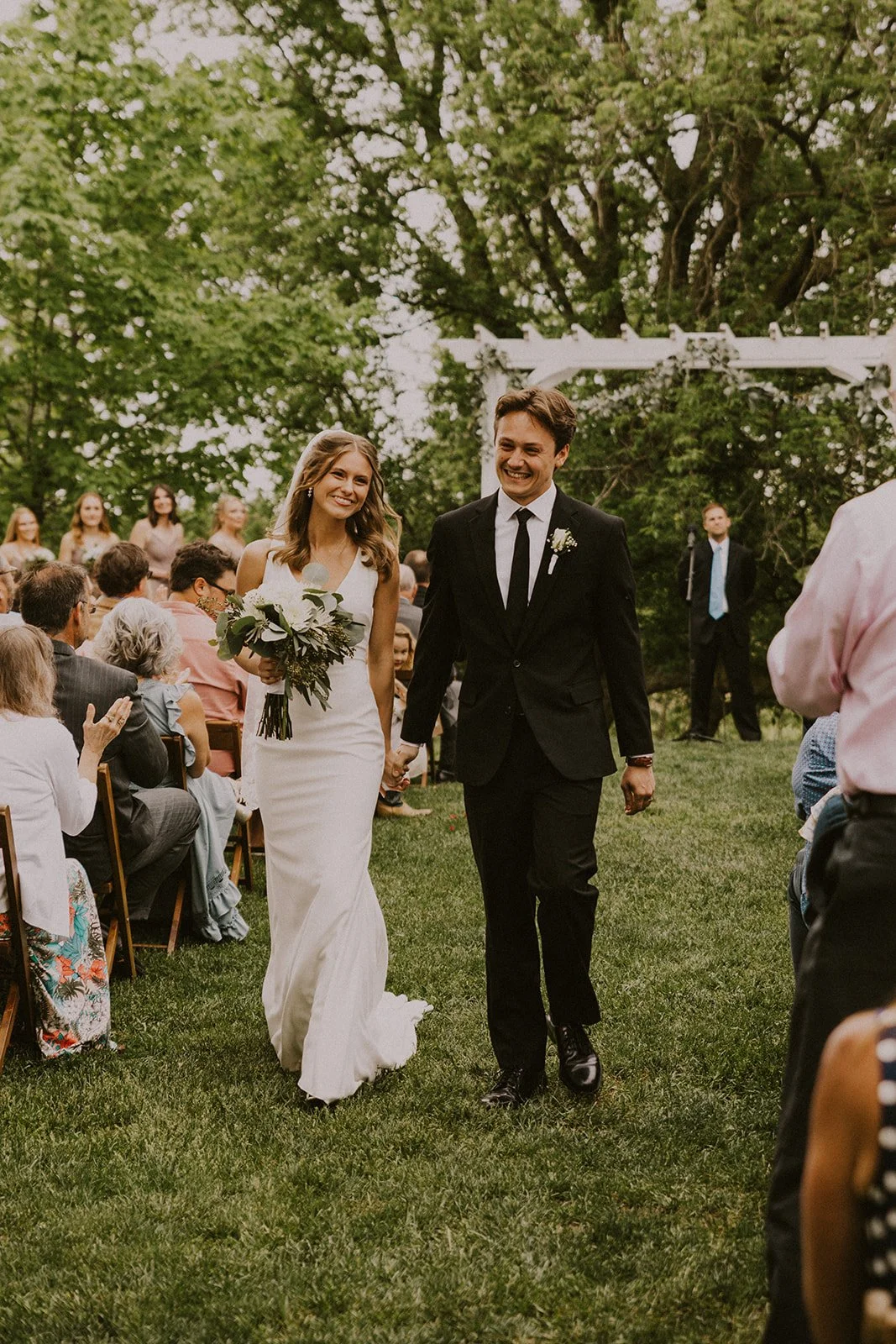 A bride and groom walk down the. aisle after getting married in Michigan