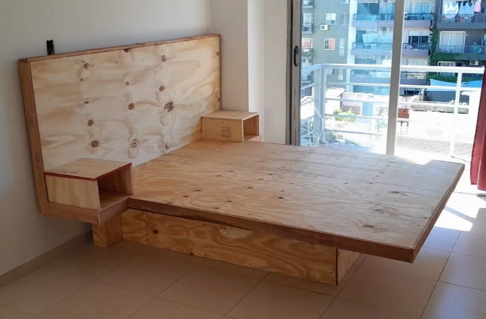 Hollow-frame floating bed by Eva Luna Ortiz Sálwet. Engineered with 14 perimeter slats and no center post to maximize storage. Includes a hinged front-panel door for sliding suitcases into the unobstructed under-bed cavity.