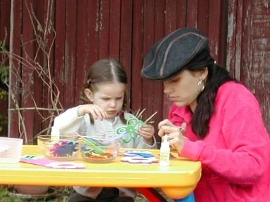 2 year old Eva Luna Ortiz and mother Laura Salwet paint together on a craft table.