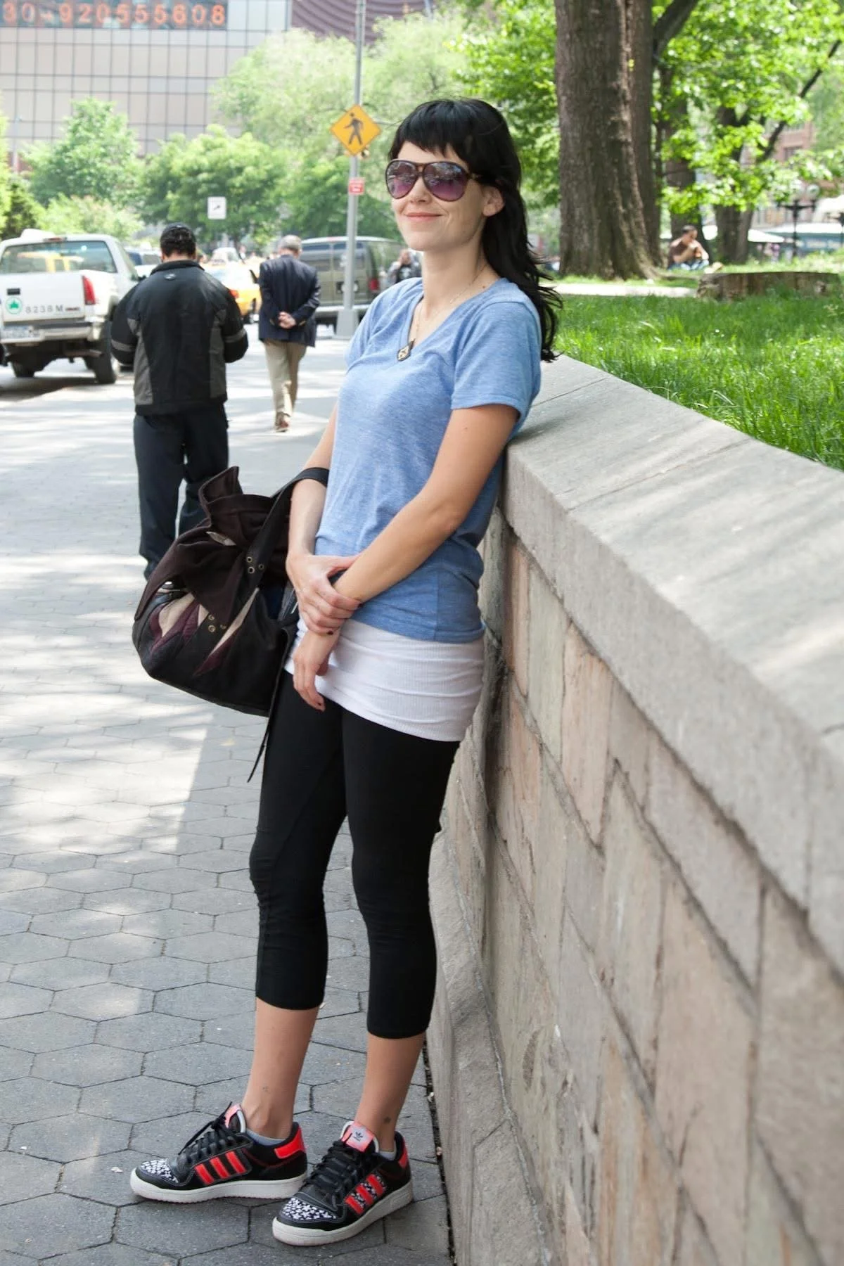 Laura Salwet appears on the UCLA campus sporting casual black yoga pants and black adidas with neon orange stripes and stars.