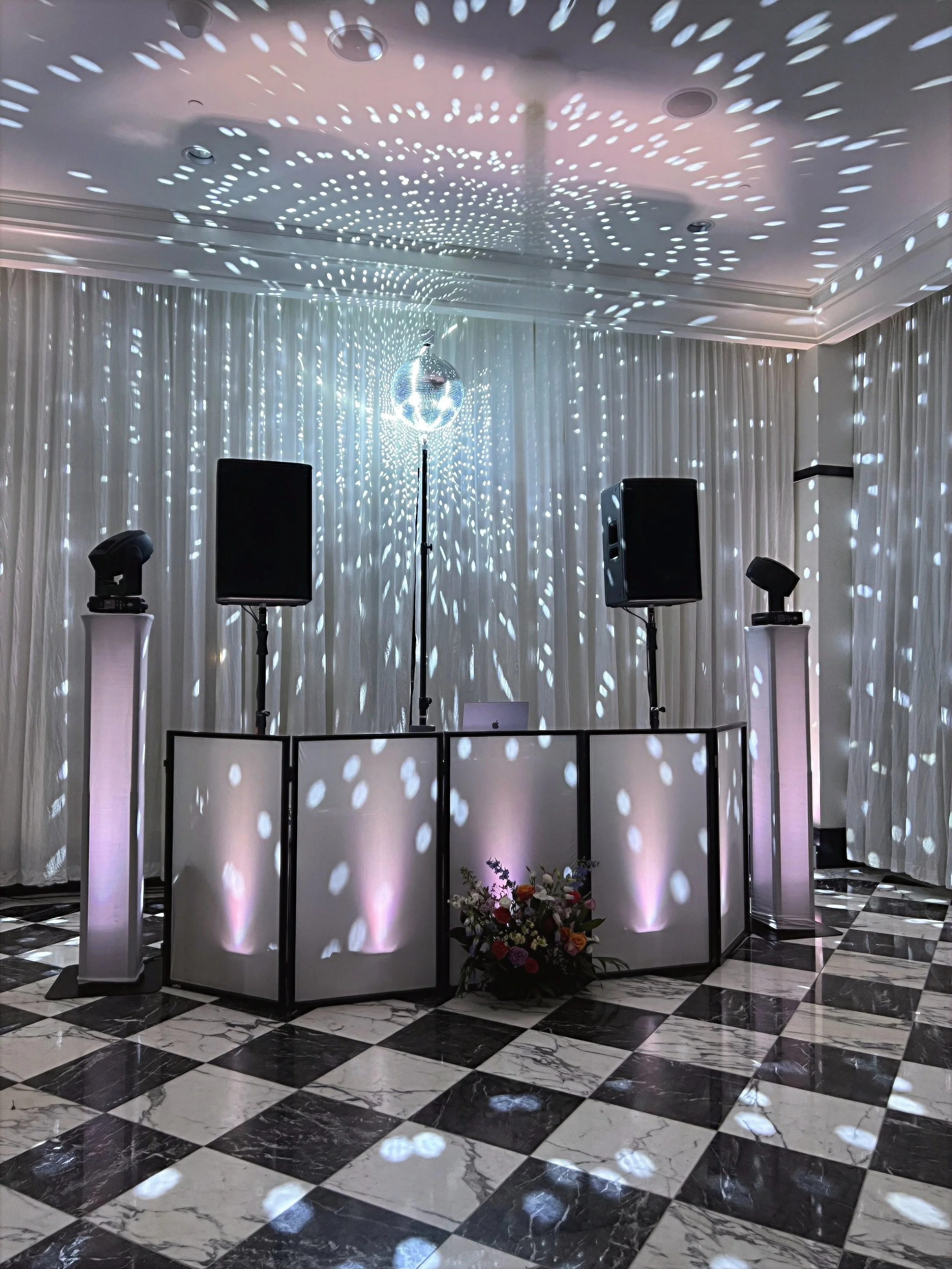Elegant wedding DJ setup by Versamix Music featuring uplighting, mirror ball effects, and refined event lighting design.