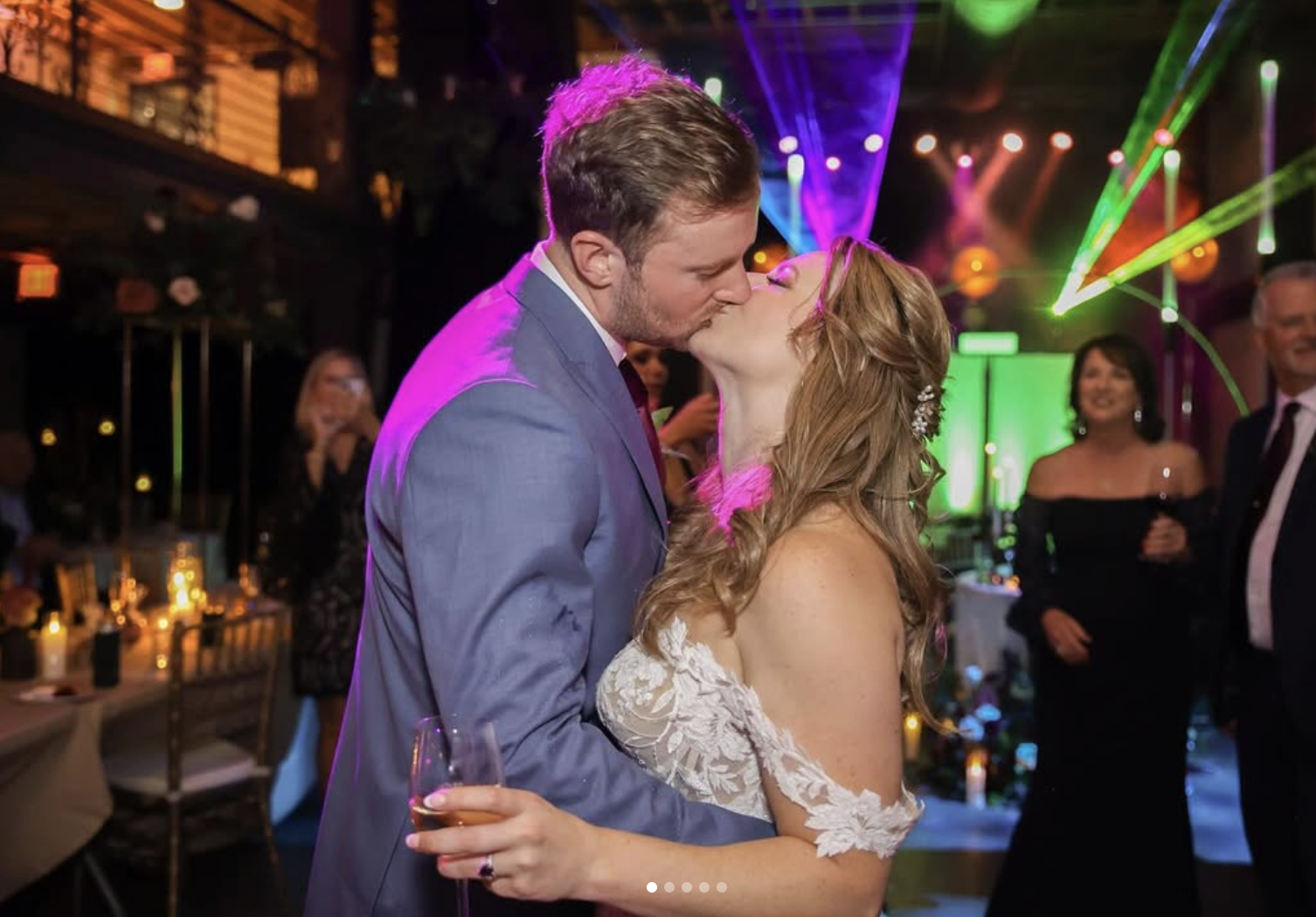Bride and groom sharing a kiss on the dance floor with colorful DJ lighting at their Savannah wedding.