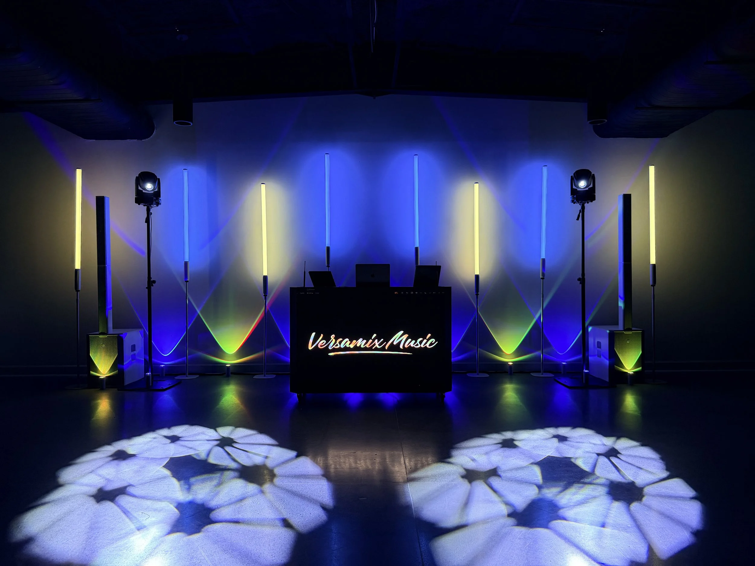 Modern DJ setup by Versamix Music featuring a sleek LED booth with custom lighting, Titan Tubes, and intelligent moving lights creating a vibrant and elegant atmosphere.
