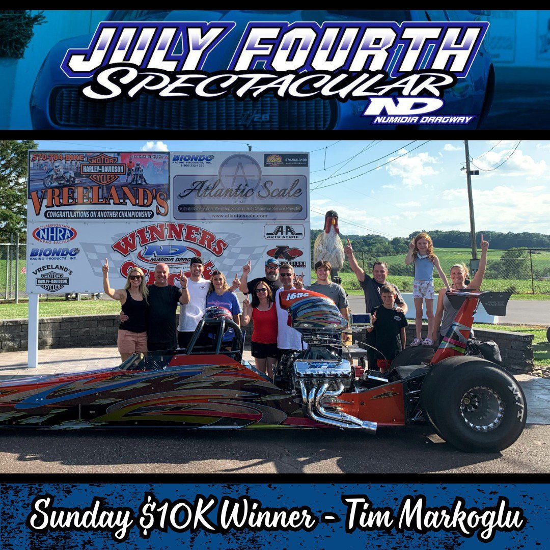 Group of people celebrating at Numidia Dragway with a drag racing car, sign indicating a Sunday $10,000 winner event, and banners from sponsors in the background.