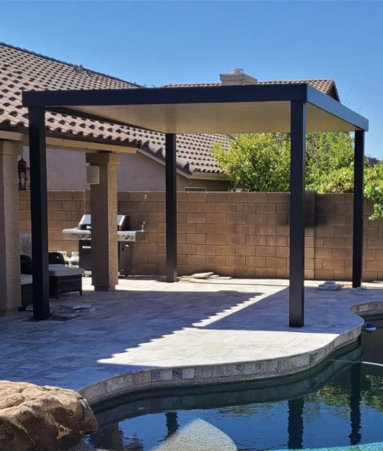 Backyard patio with a shaded pergola, a barbecue grill, outdoor seating, and a swimming pool with a curved edge.
