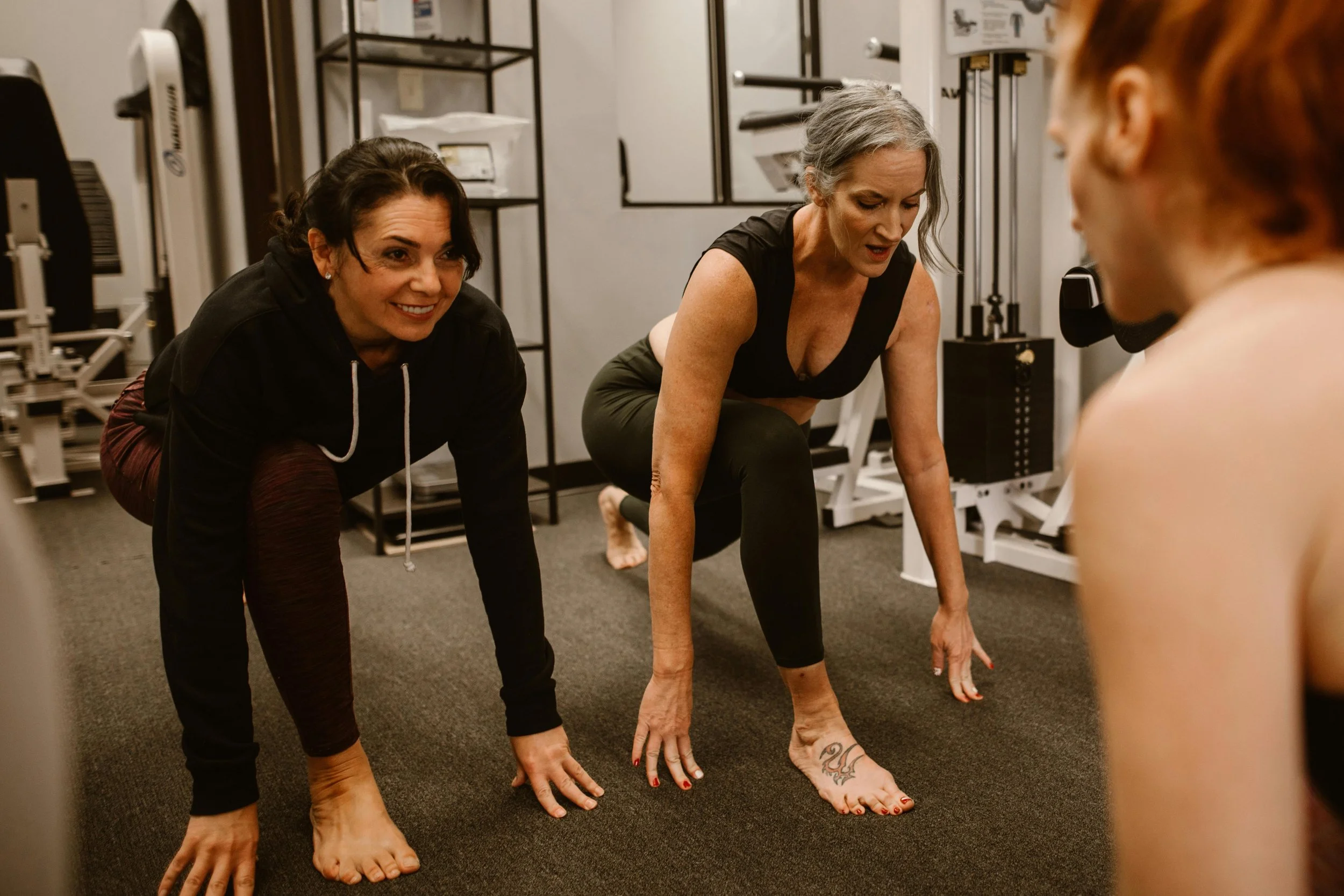 Two women stretching at gym