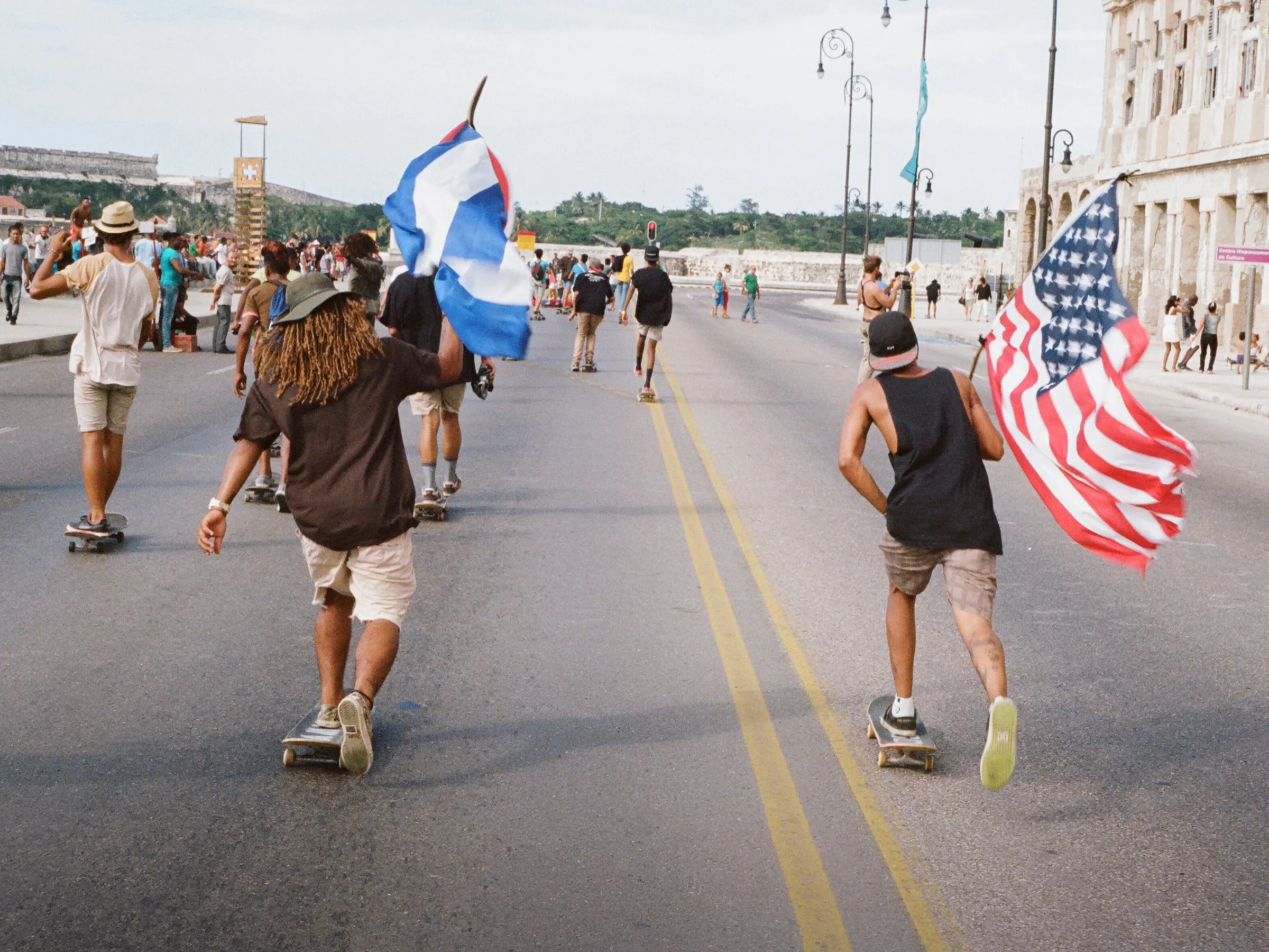 Yojani and Vampiro pushing down el Malecón with US and Cuba flags 