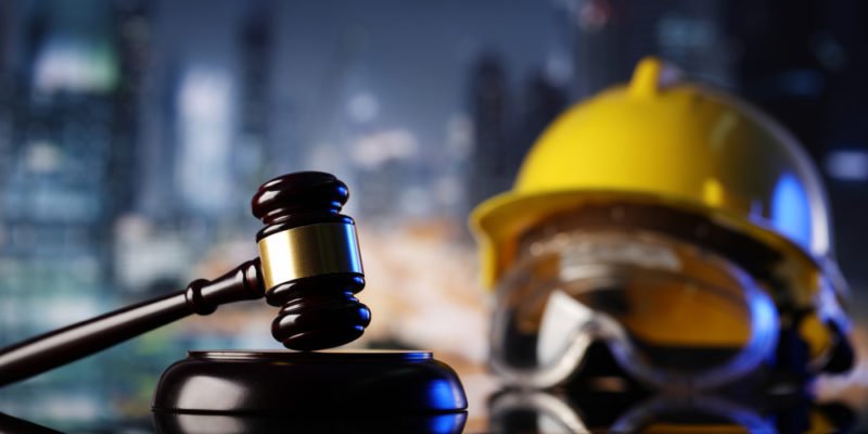 Martillo judicial y casco de seguridad en un fondo borroso