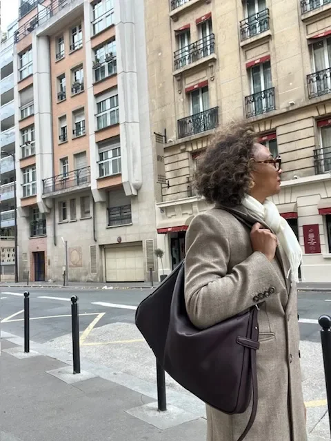 Anita Rechell standing at a Paris crosswalk while exploring the city beyond the tourist landmarks.