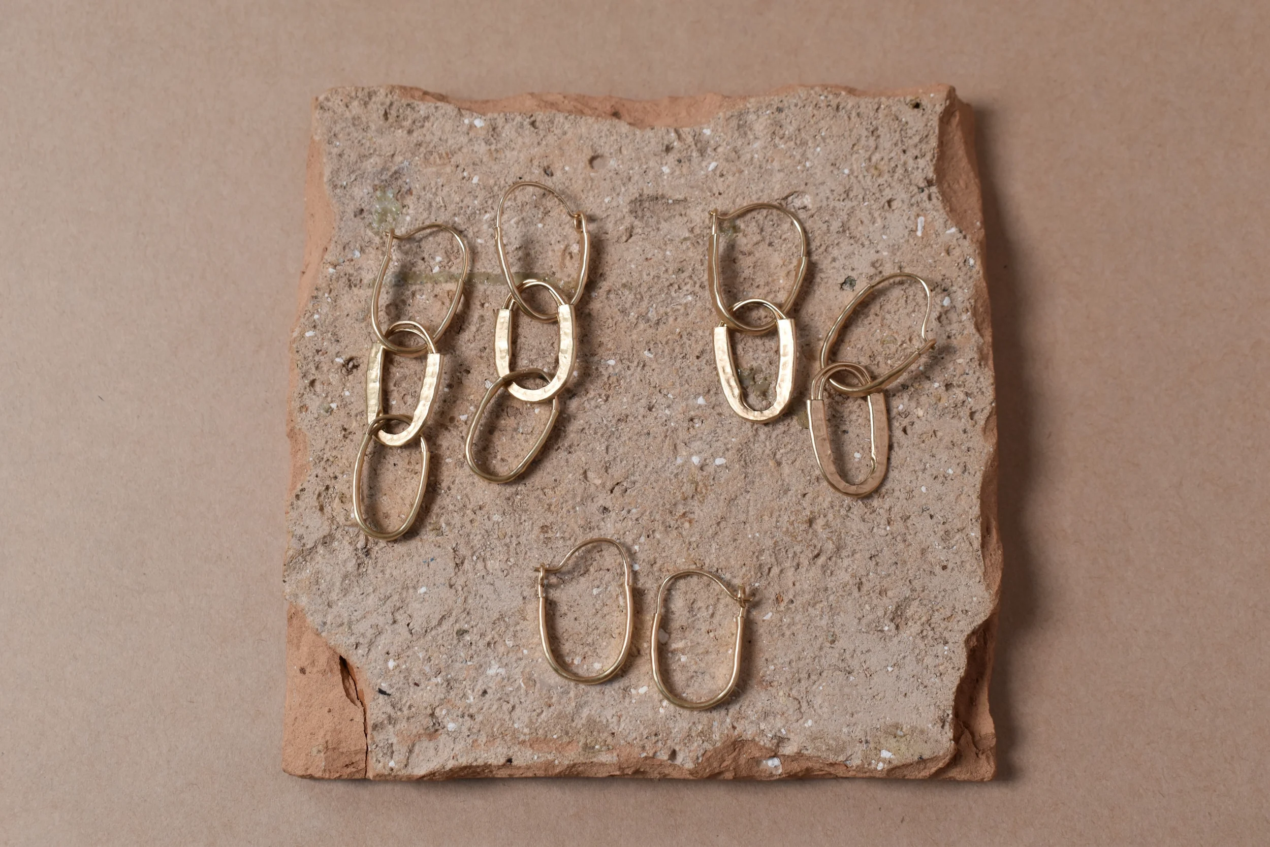 Hammered gold hoops 3 sets flat lay clay horizontal.webp