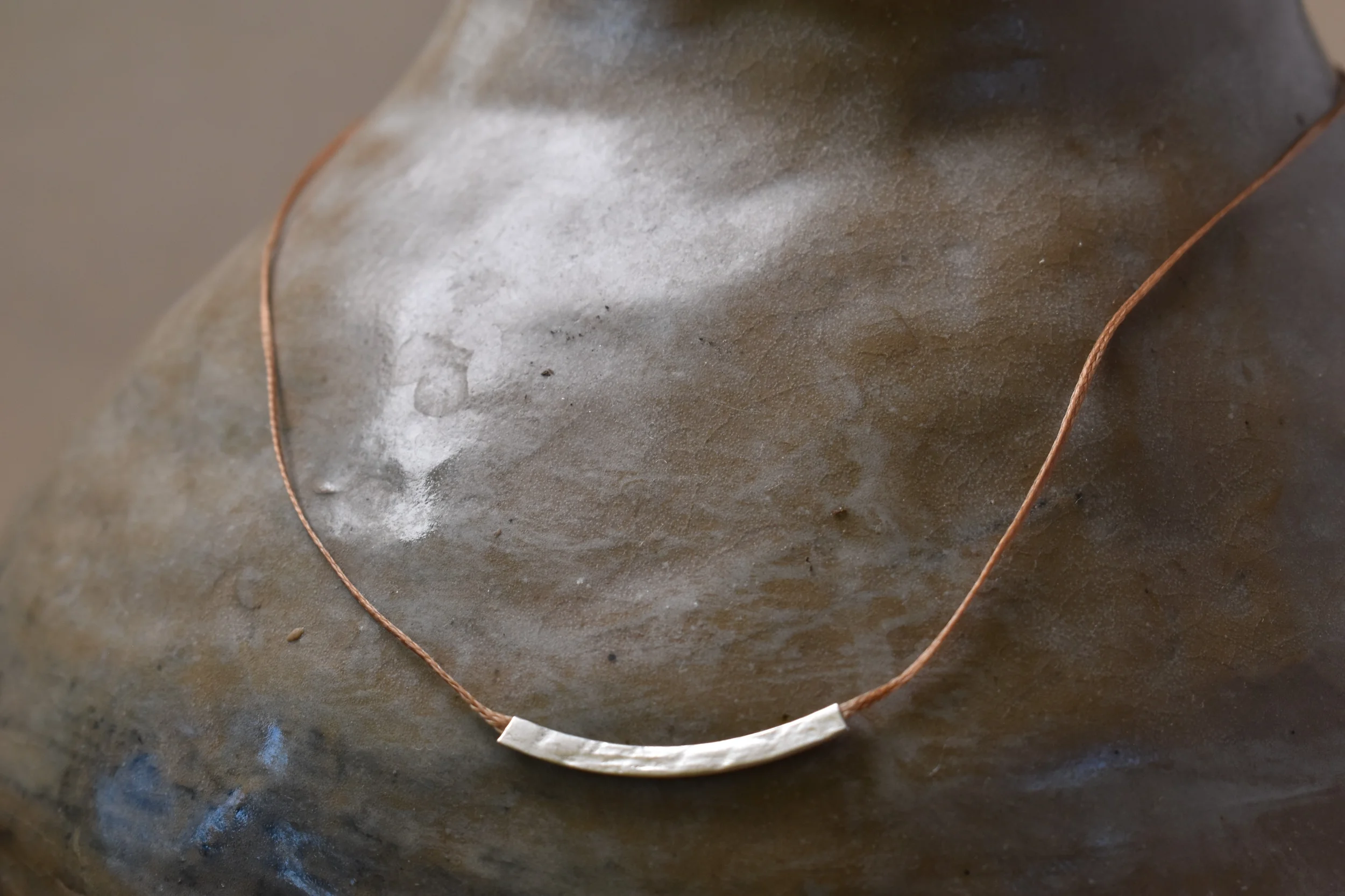 Halo necklace in silver on vase.webp