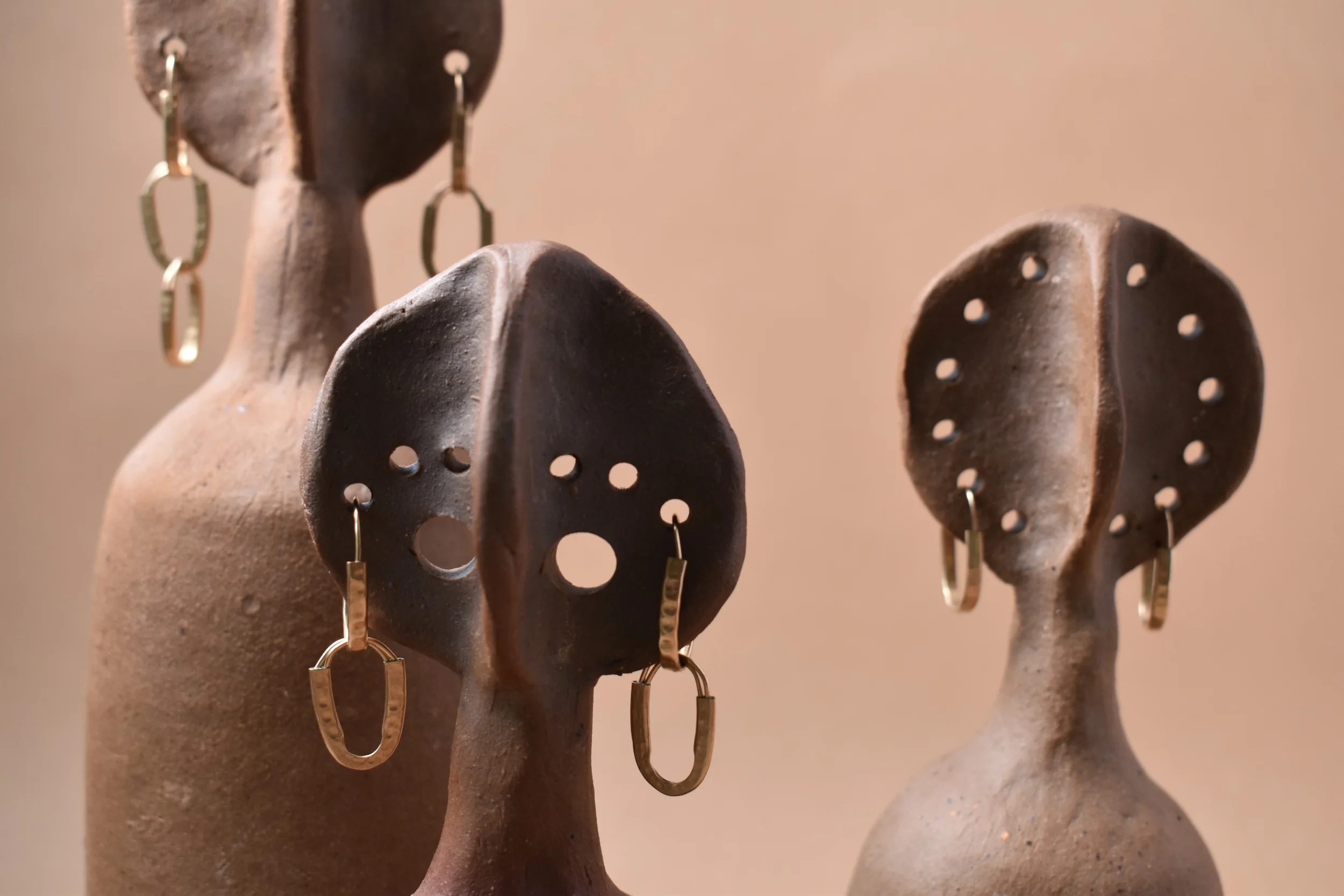Hammered gold earrings 3 sets on clay models.webp