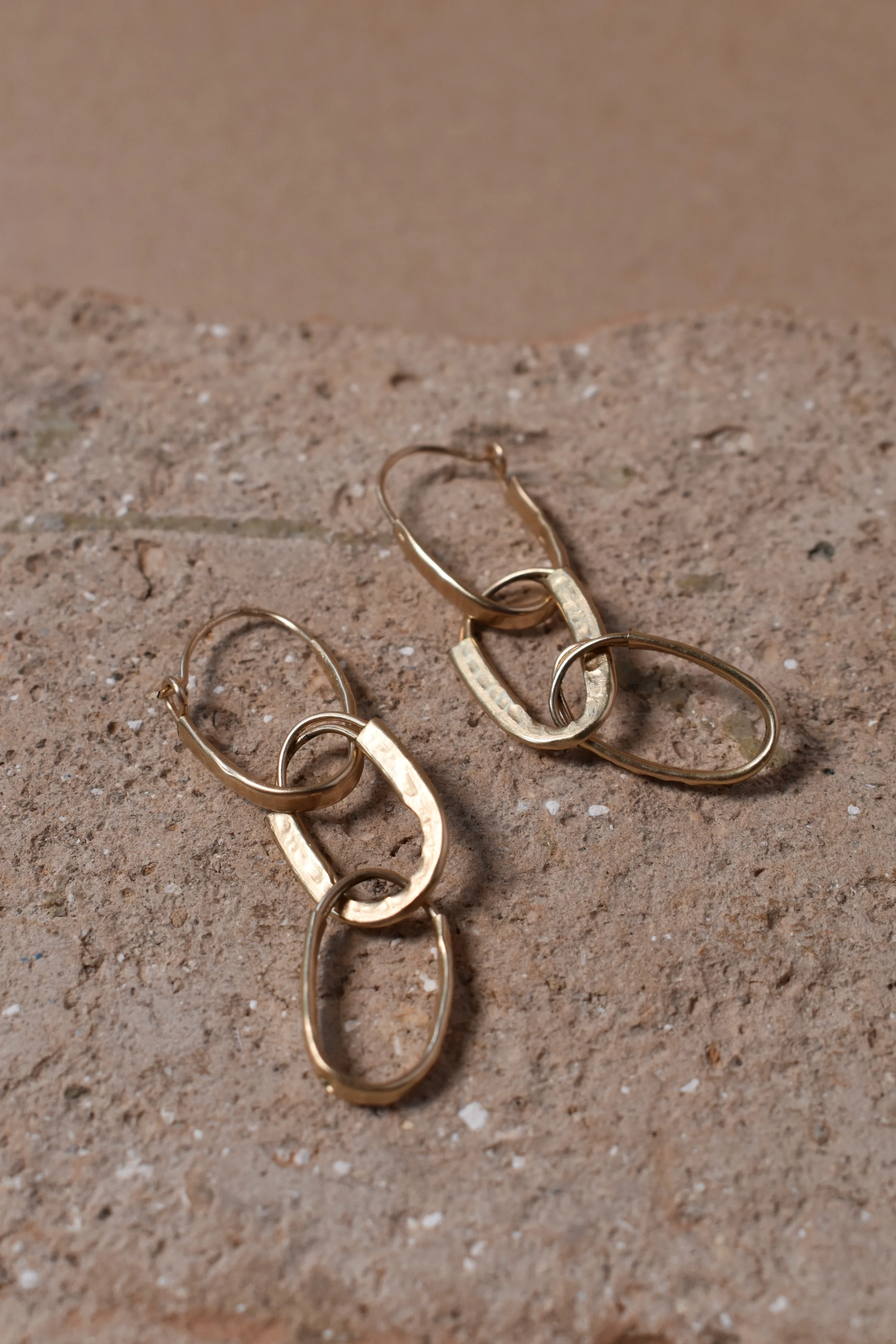 Hammered gold hoops 3 set flat lay clay vertical.webp