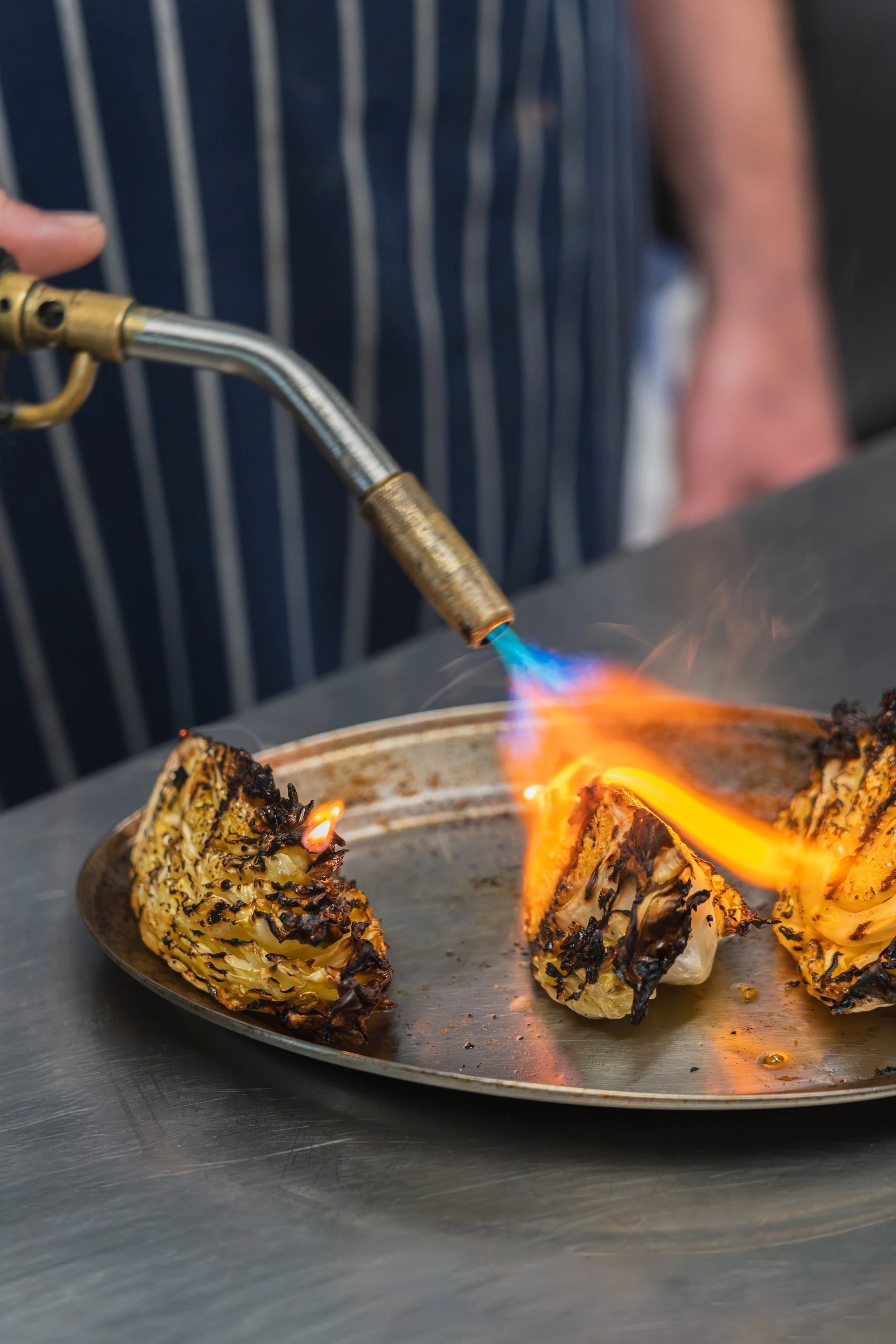 Chef using torch on grilled cabbage food photography
