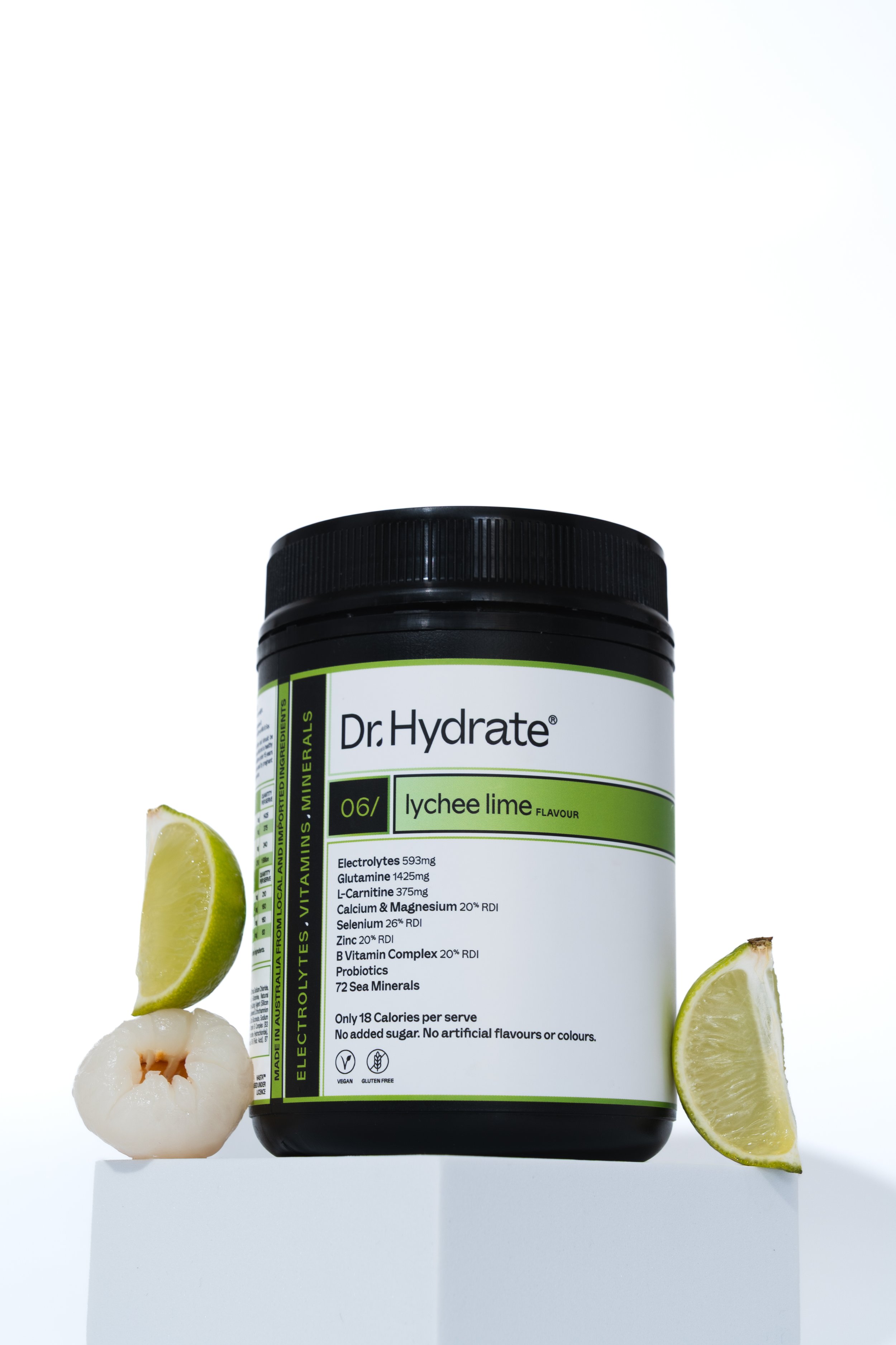 A jar of Dr. Hydrate electrolyte powder in lychee lime flavor with fresh lychee and lime slices placed around it on a white surface against a white background.