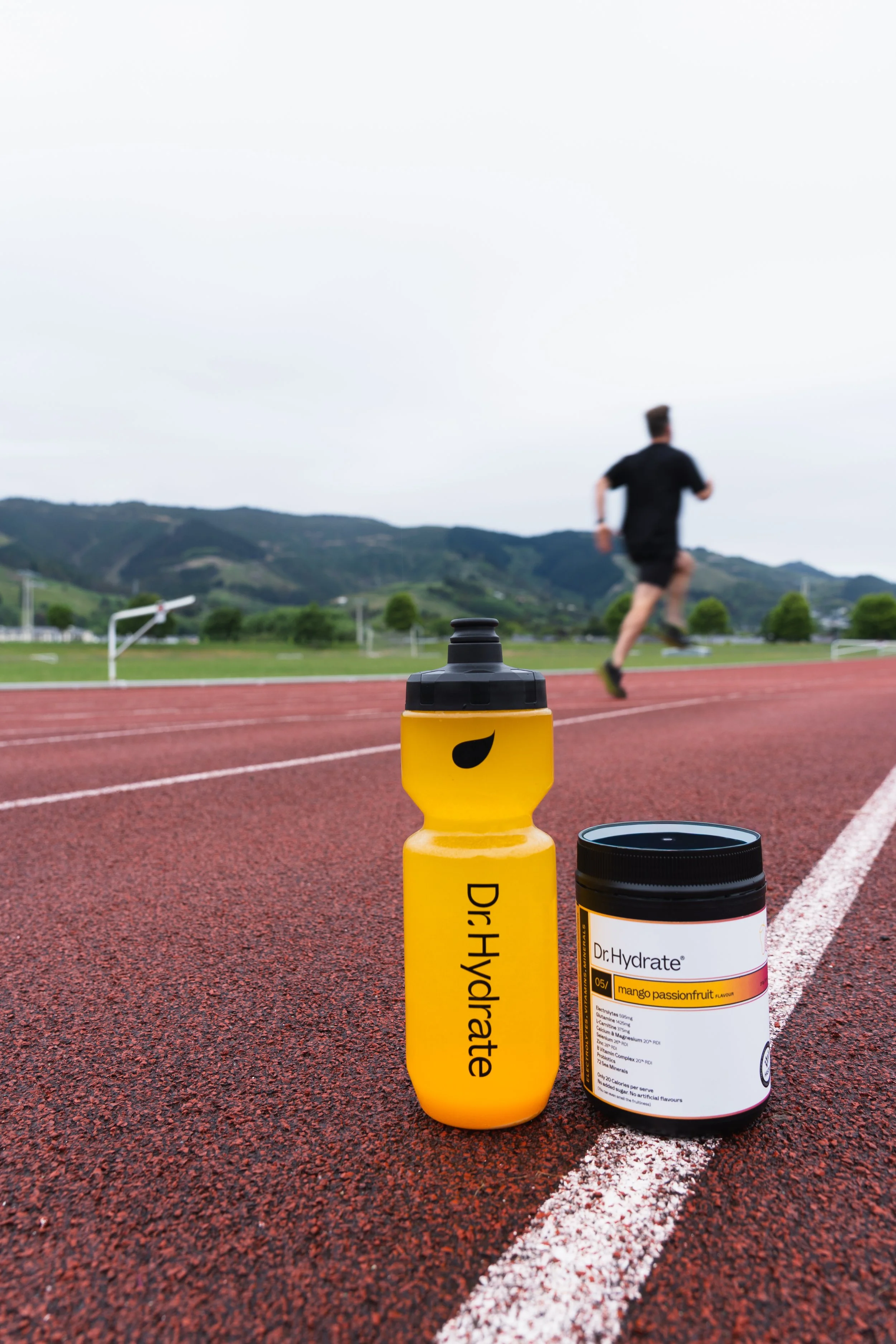 Mango Passionfruit Dr. Hydrate electrolytes with runner on running track
