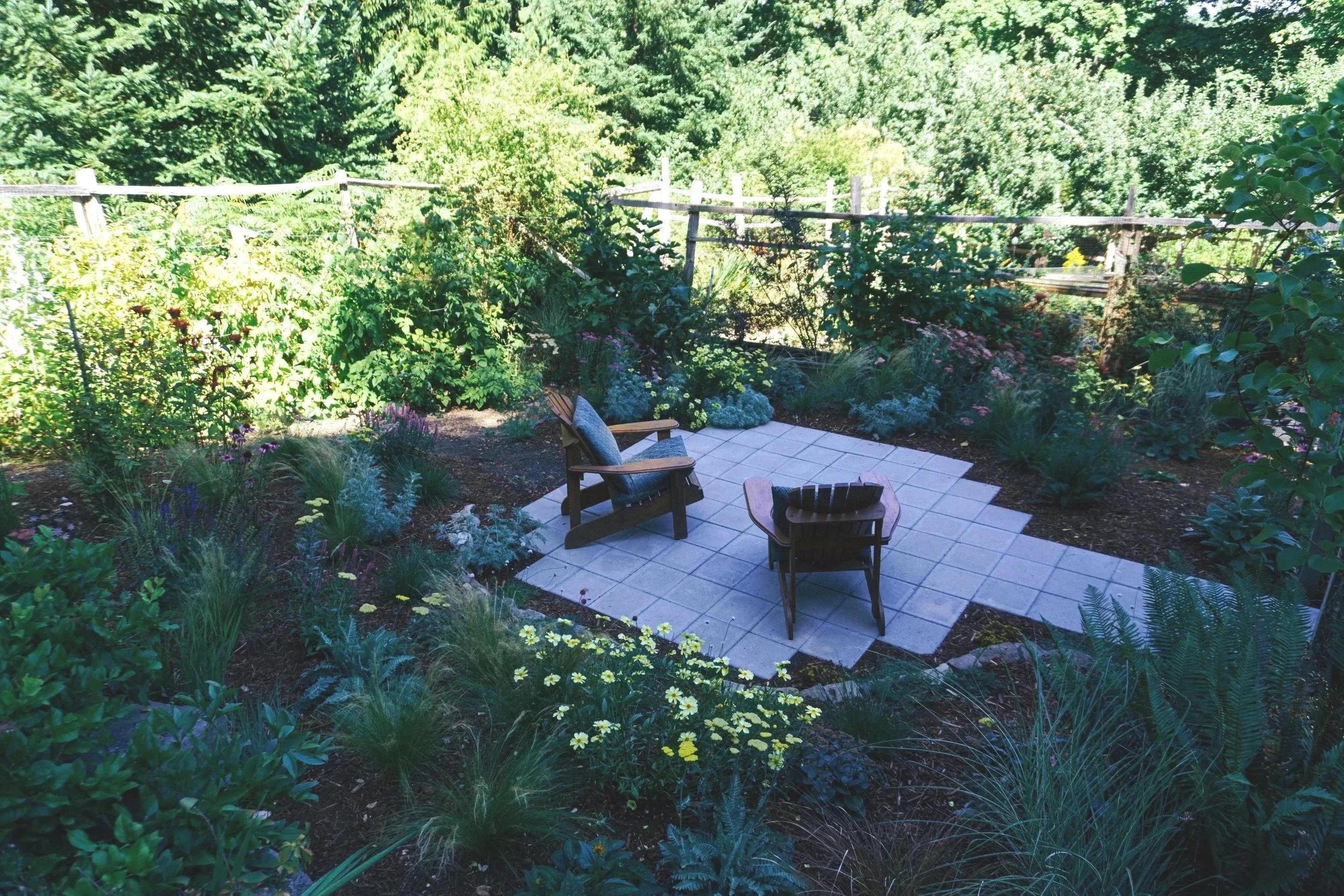 A custom garden patio, surrounded by lush green plants and flowers