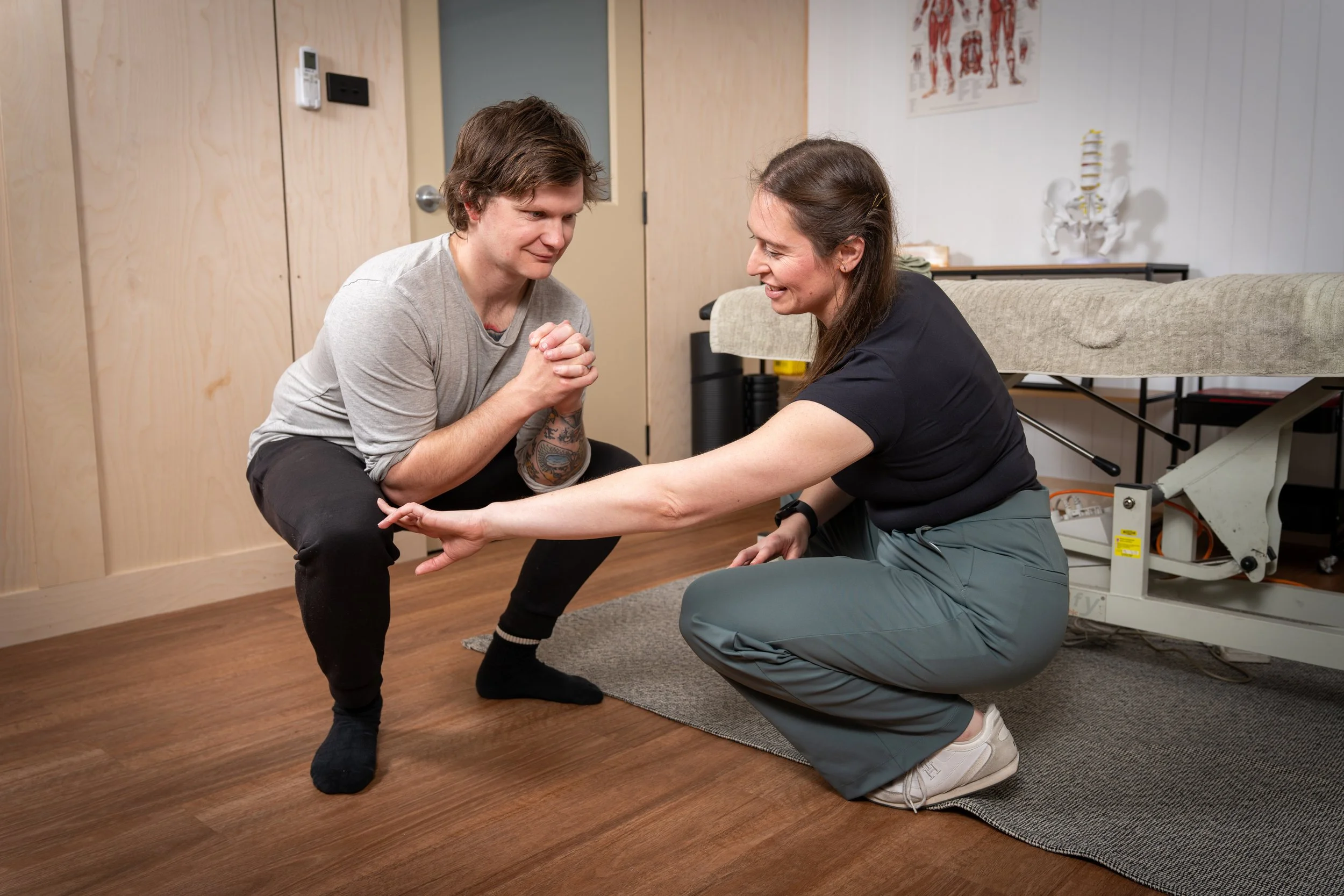 An Osteopath performing a physical therapy exercise with a client/patient in a clinic space