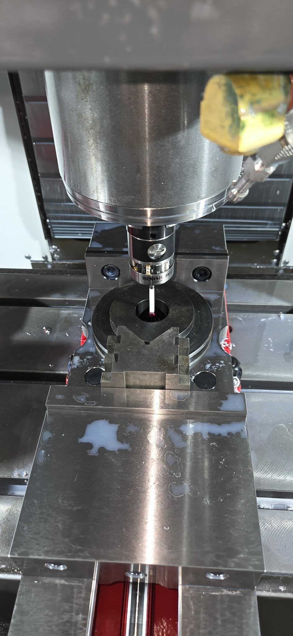 A laboratory instrument, possibly a mass spectrometer or chromatography device, with metal components and a liquid spill on the surface.