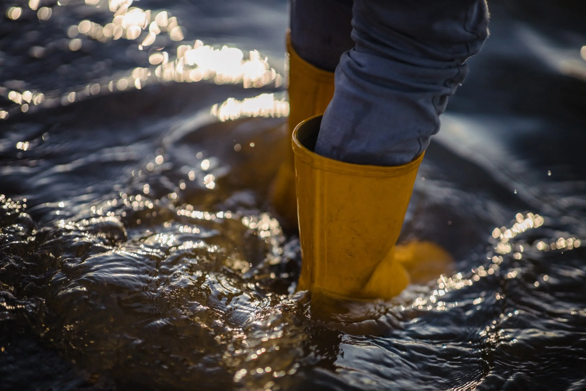 person-blue-denim-jeans-yellow-boots-standing-water.jpg