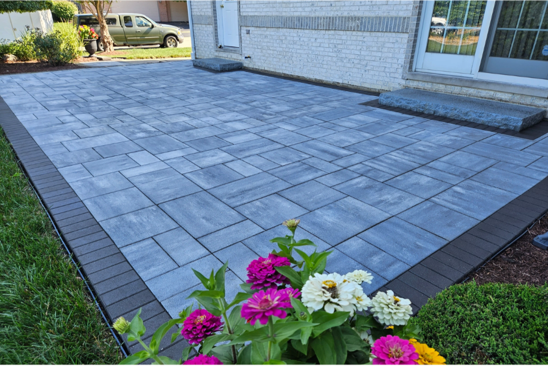 Blue-grey stone paver patio with dark border trim..png