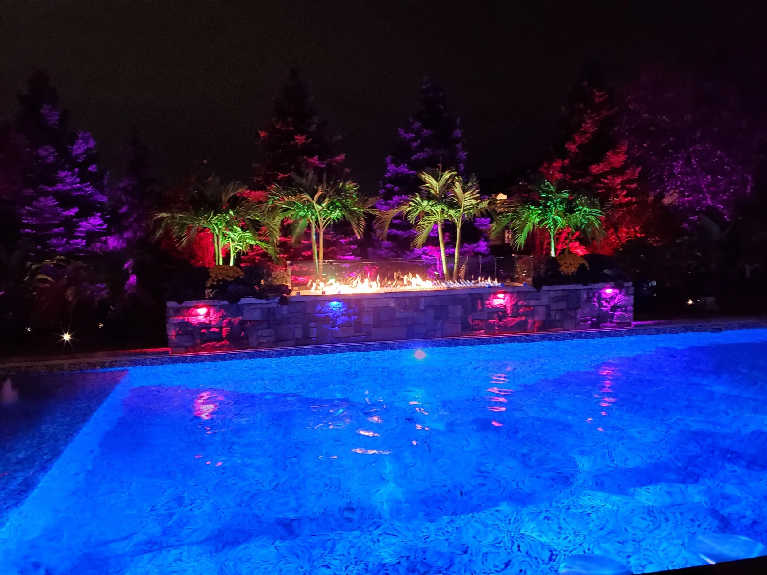 Pool lighted up at night created by Brick paver Creations
