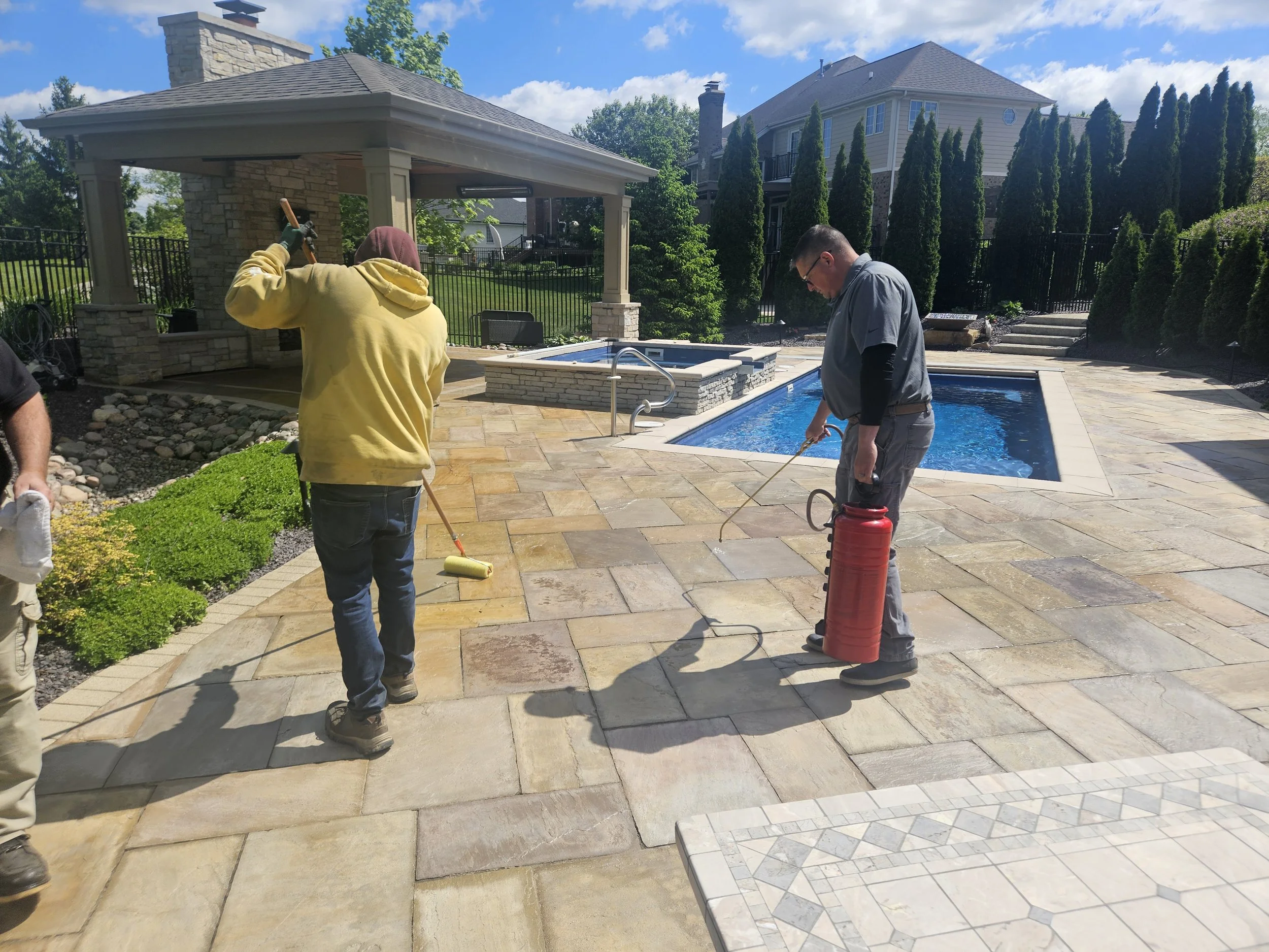 Sealing brick pavers around a pool.