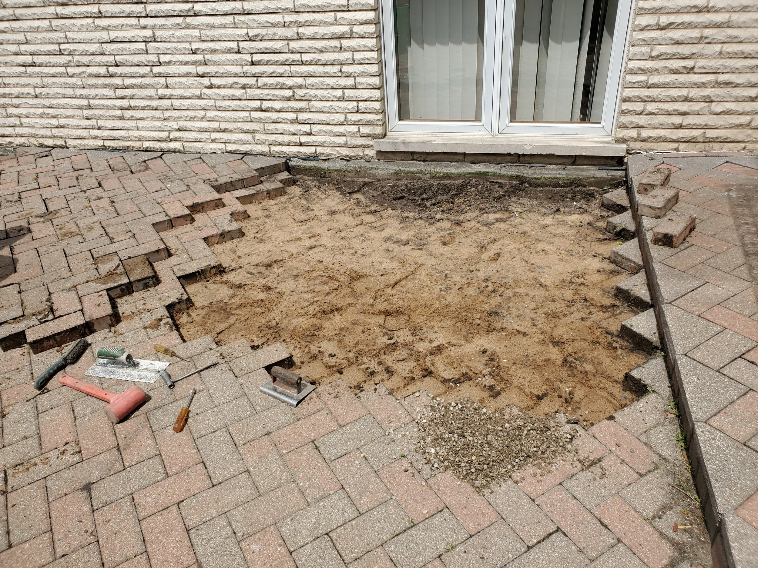 Brick paver patio being raised because of improper base.